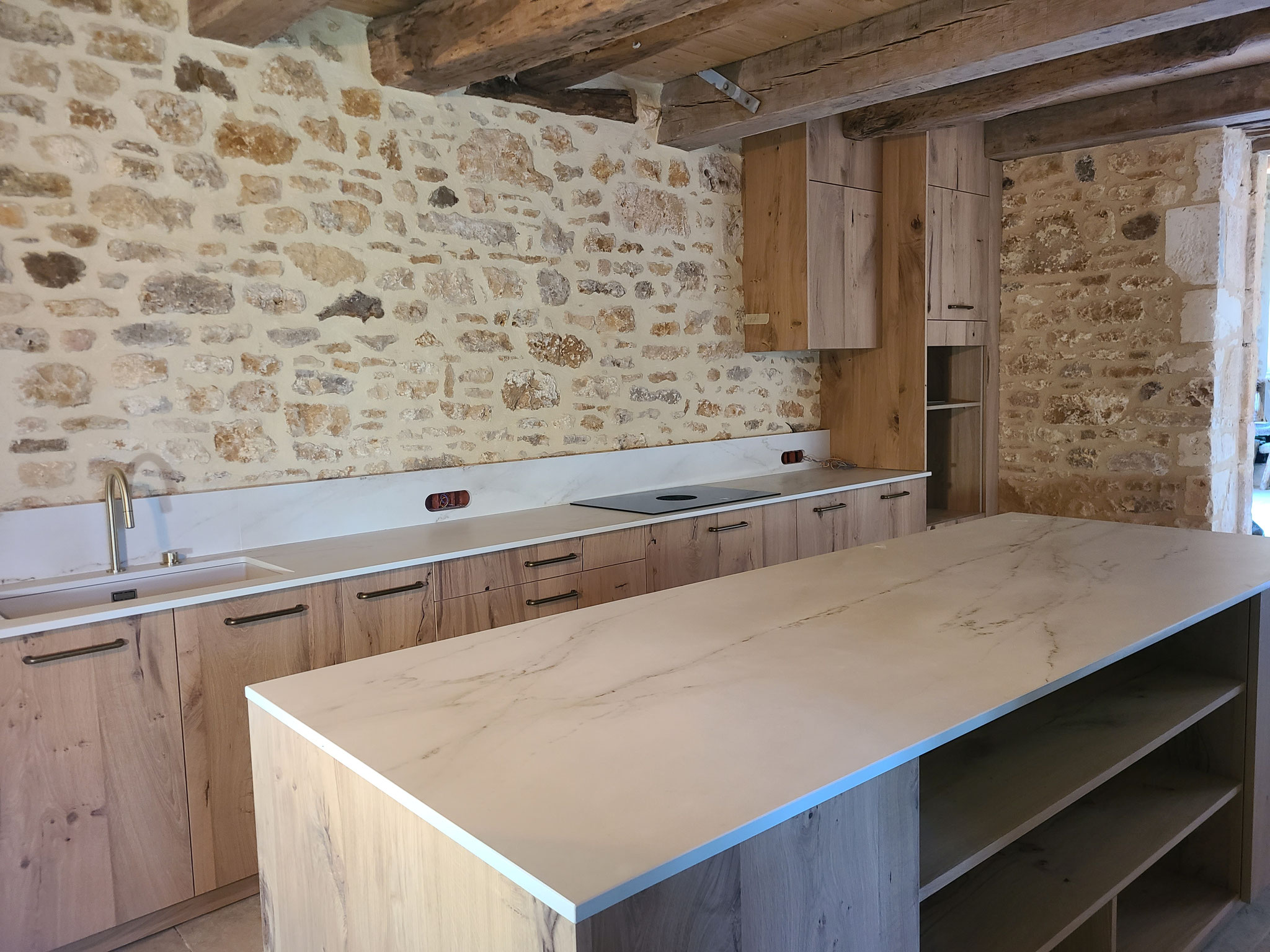 La cuisine associe des façades en bois au style rustique à un plan de travail en Dekton, garantissant à la fois esthétique, durabilité et facilité d’entretien.  Le projet offre aujourd’hui un équilibre entre tradition et modernité