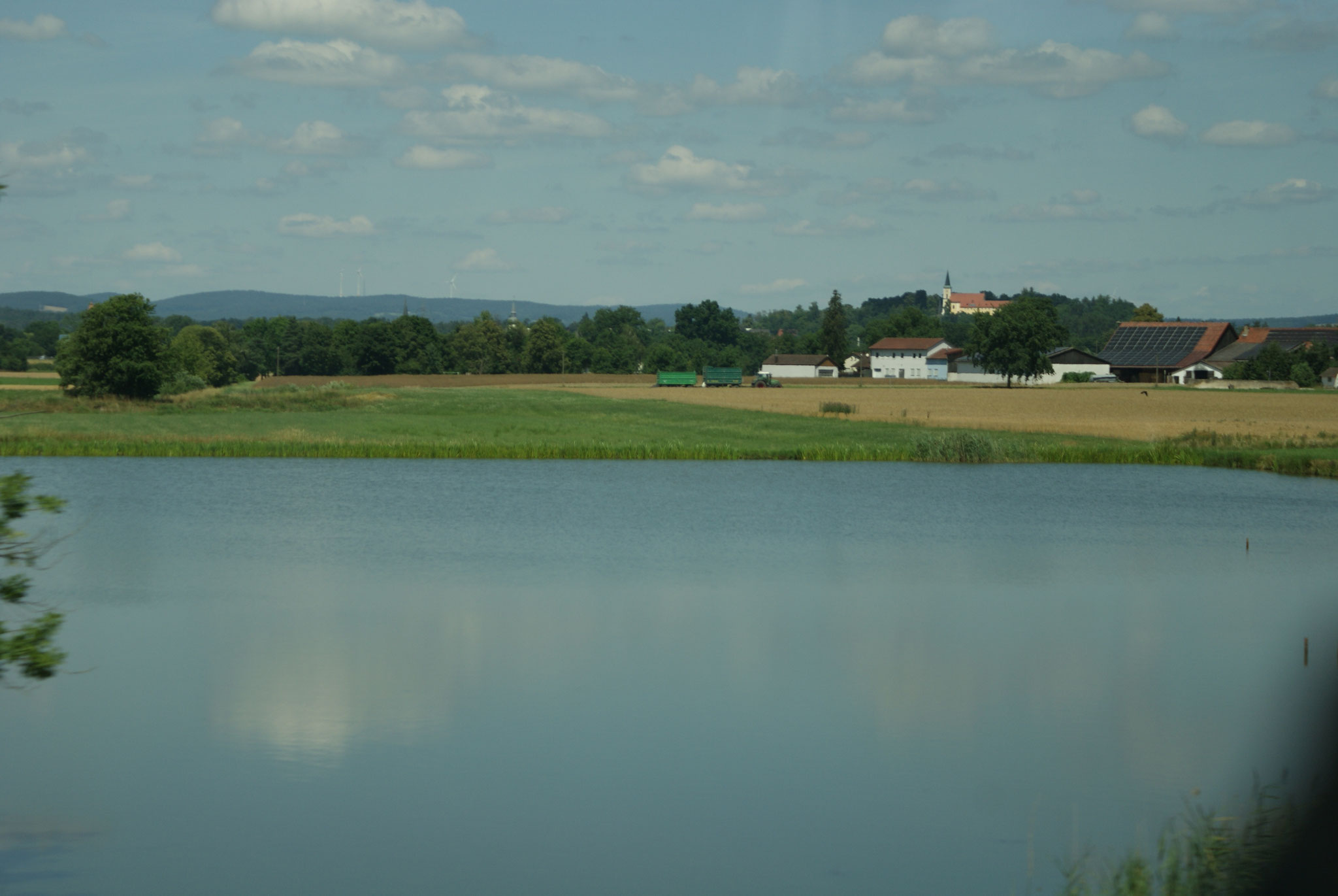 Hinter dem Teich liegt Schwarzenfeld mit der Miesbergkirche
