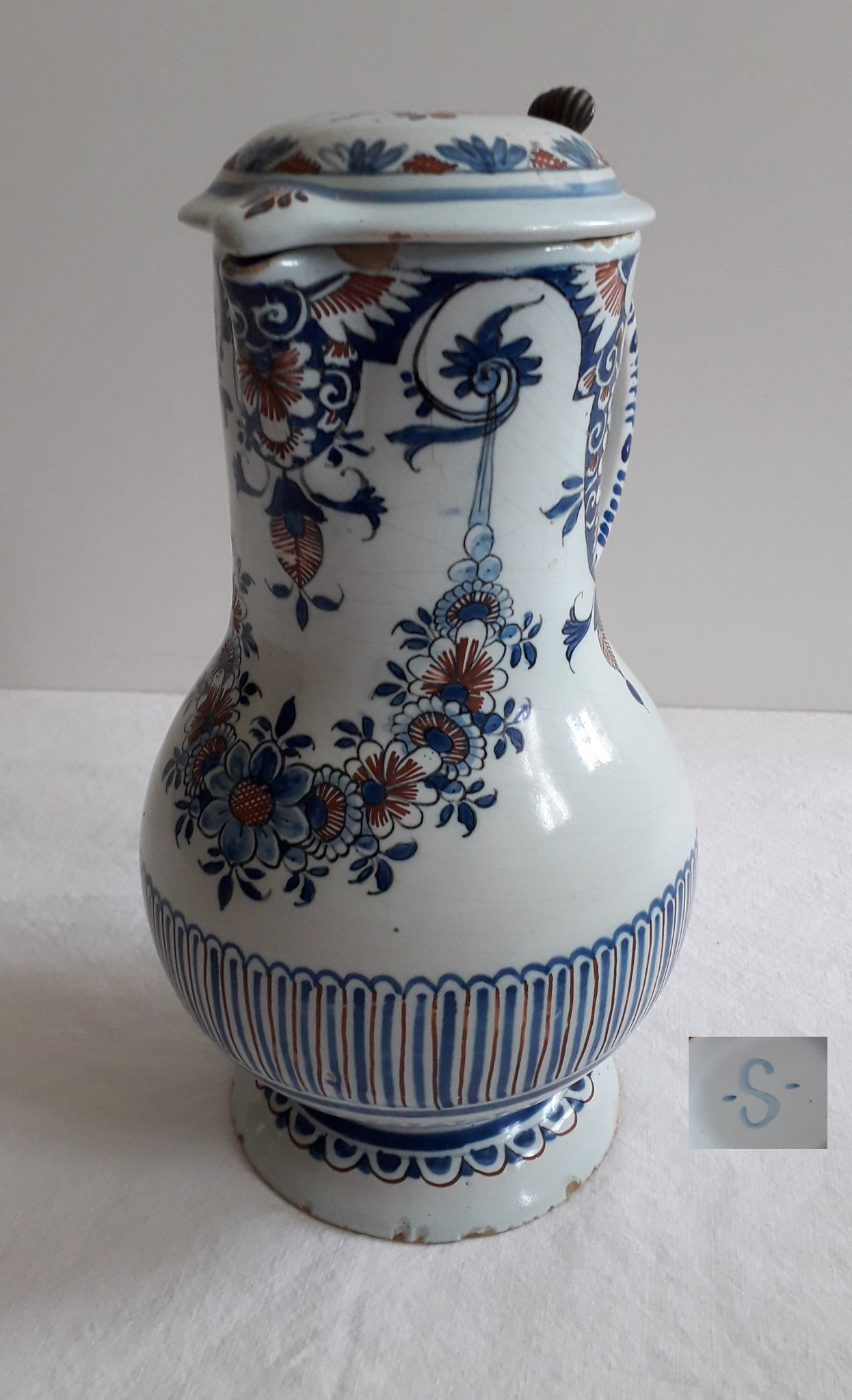 Pot à l'eau (chaude) aux  lambrequins - Haut 24 l avec anse 18 Marqué -S- : ce pichet comporte un décor en bleu et rouge de guirlande fleurie, de lambrequins et de faux godrons inspiré à Sinceny par Rouen.
