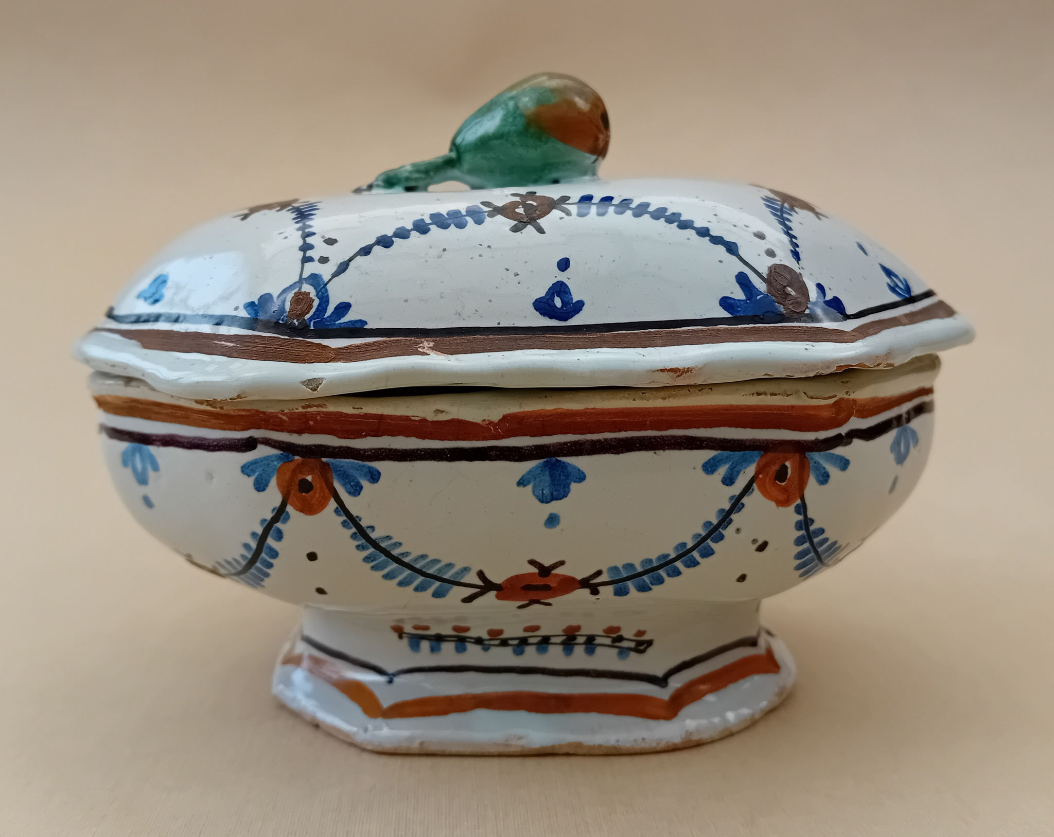 Boîte à épices - Haut. 9 Long. 13 Larg. 8.5 : boîte à épices de forme octogonaleet décoréedeguirlandes avec une prise en forme de fruit mais sans la feuille.