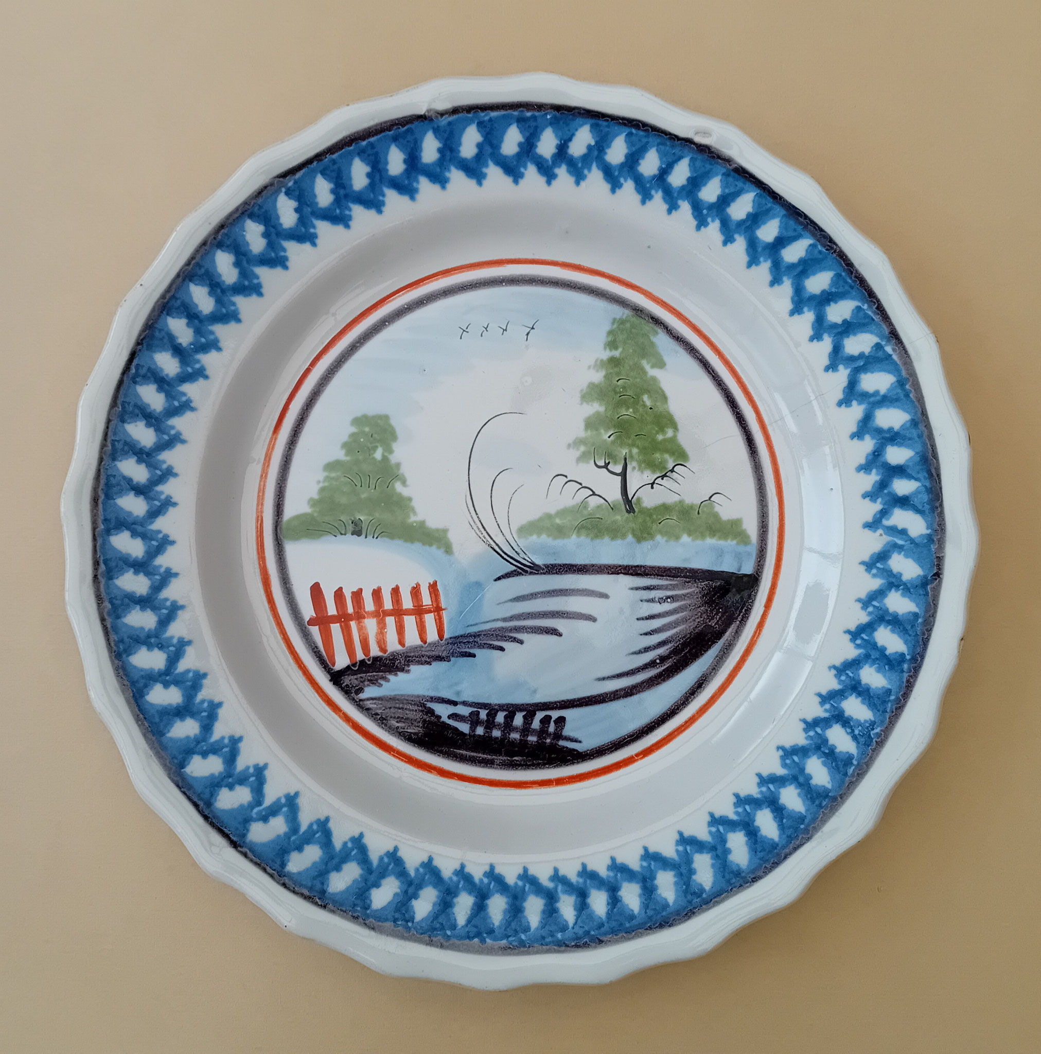Assiette - Diam. 23 : assiette polychrome dont il existe de nombreux exemplaires et dont le décor a été repris assez fidèlement sur les faïences de Ferrière-la-petite.