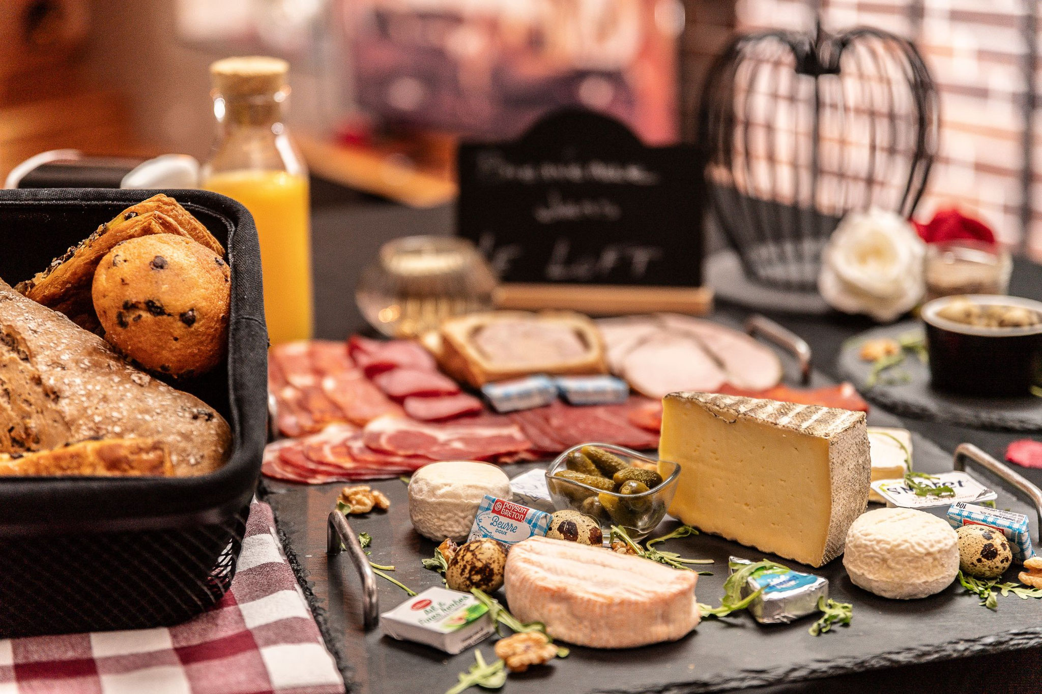 Plateau de brunch terroir avec charcuterie et fromages locaux, service petit-déjeuner livré en appart-hôtel spa en Alsace-Lorraine.