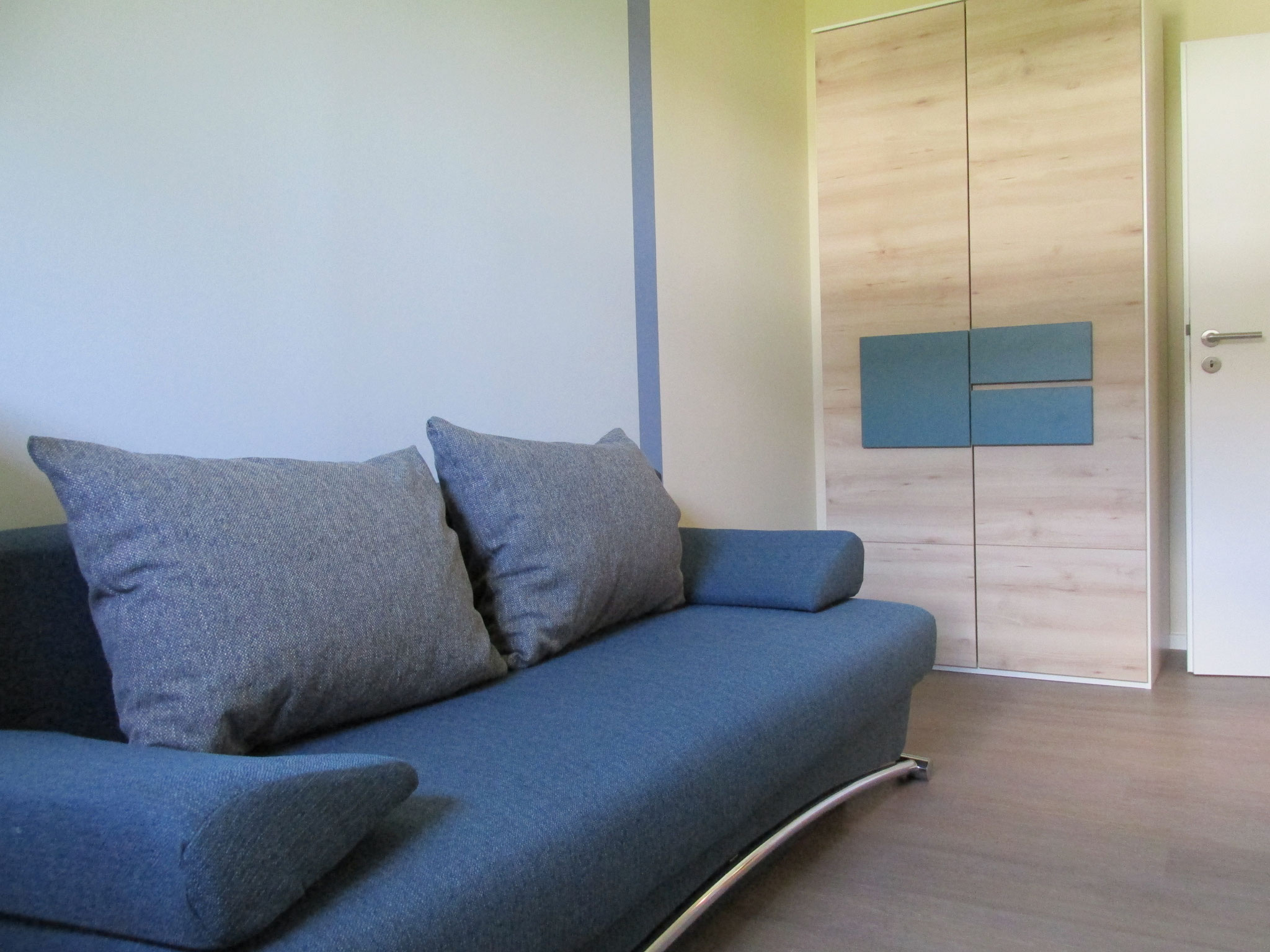 Foto Kinderzimmer mit Kleiderschrank und einem Schlafsofa