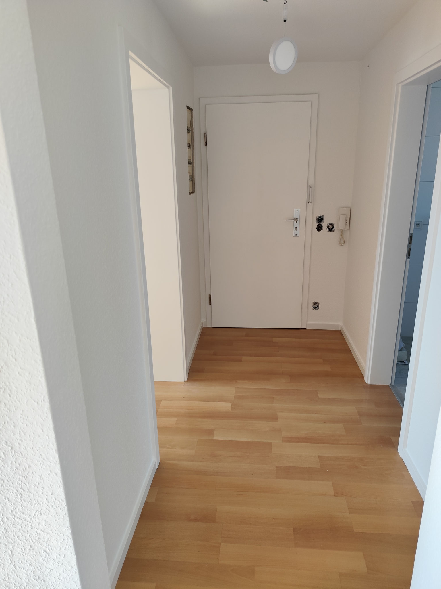 Flur mit neuer Tapete und neu lackierten Türen.
