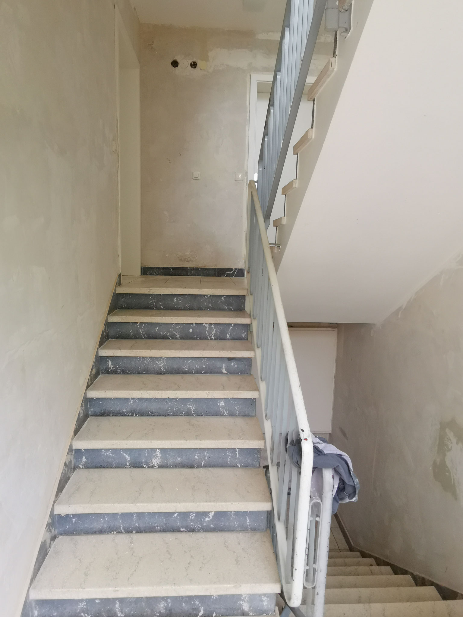Treppenhaus zeigt unrenoviert. Wände mit bereits entfernter Tapete. 