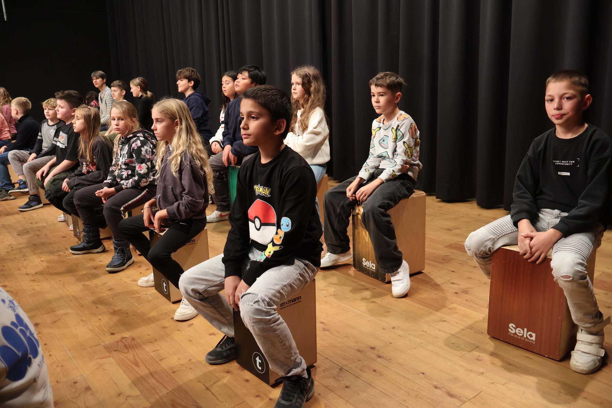 In bis zu drei Reihen saßen die Kinder auf der Bühne