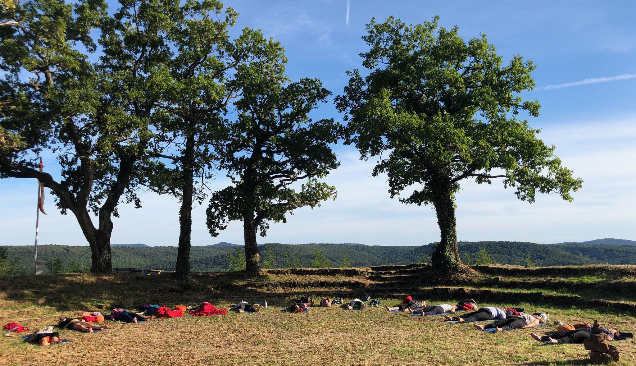 Deep relaxation in Mother Natures arms open air under the blue sky - Yoga Retreat with Beate Laudien