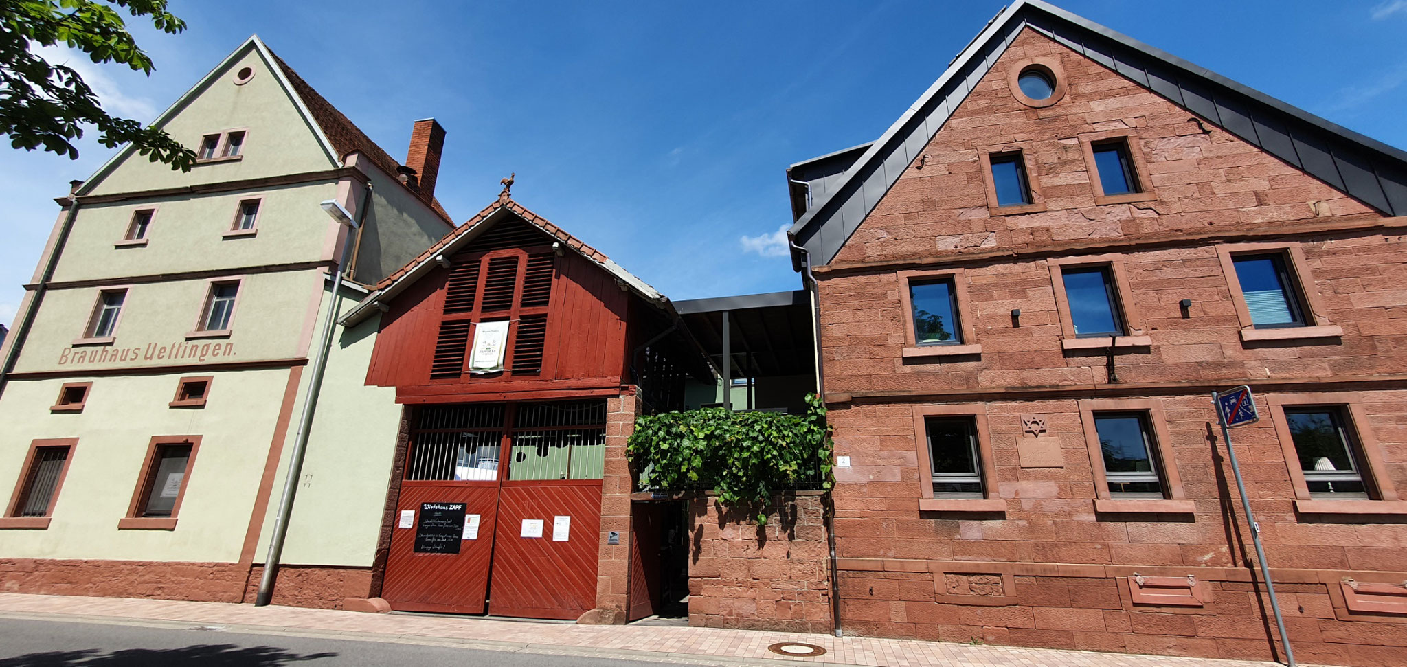 Von links: Brauerei, historisches Kühlschiff in rot und Wirtshaus