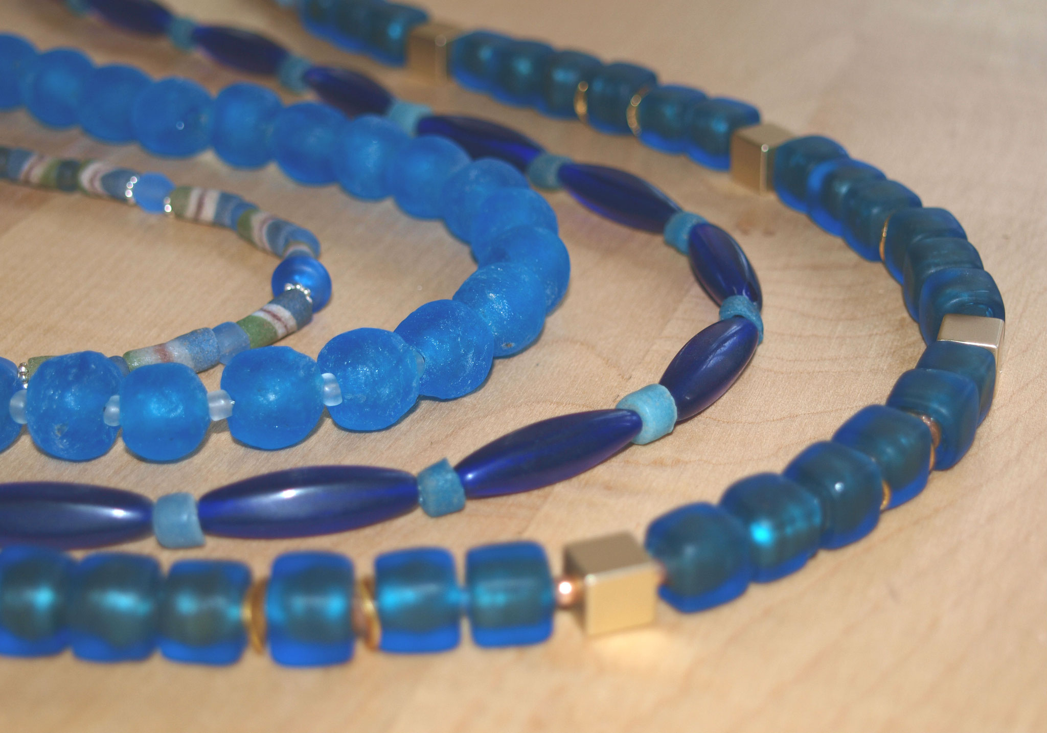 v. vorn: schimmernde Goldfolienperlen; antike kobaltblaue böhmische Glasperlen;  azurblaue Krobos; Lampworkperlen