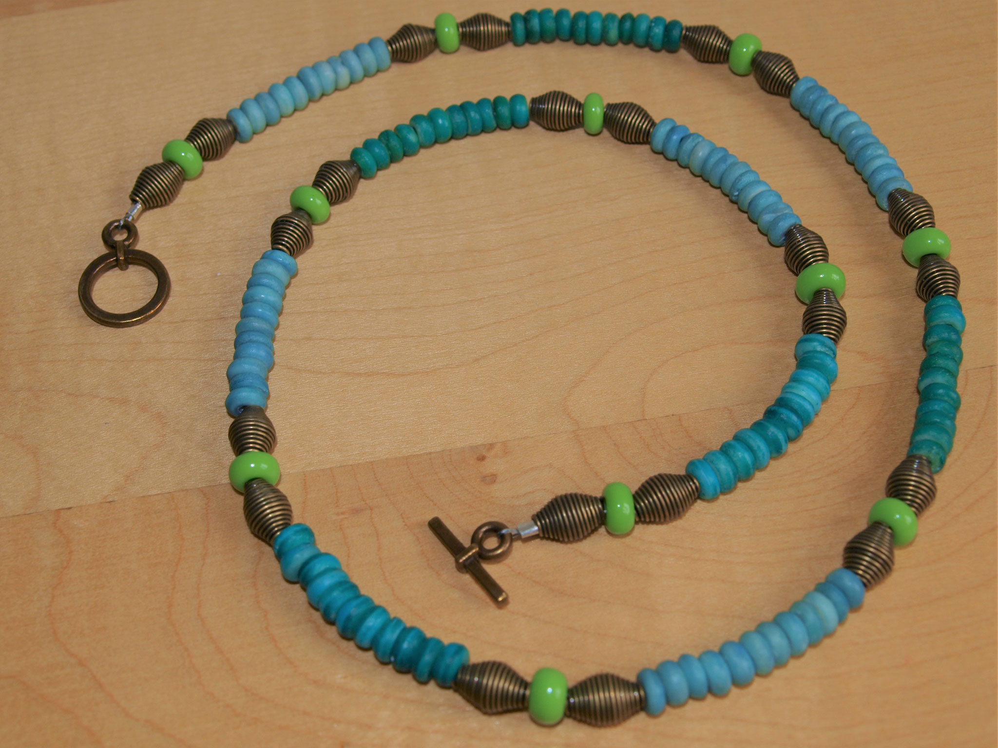 Sommerkette in blaugrün aus farbigen Holzscheibchen, Glasperlen und bronzefarbenen Metallelementen