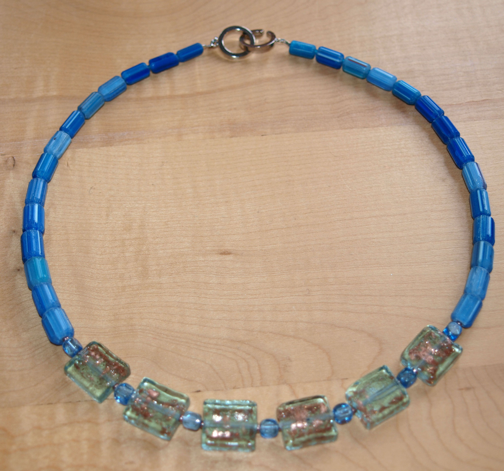 Schöne blaue Kette aus hellblauen Glasquadraten mit Goldstaub- "Innenleben"  und indischen blauen Chevronperlen.