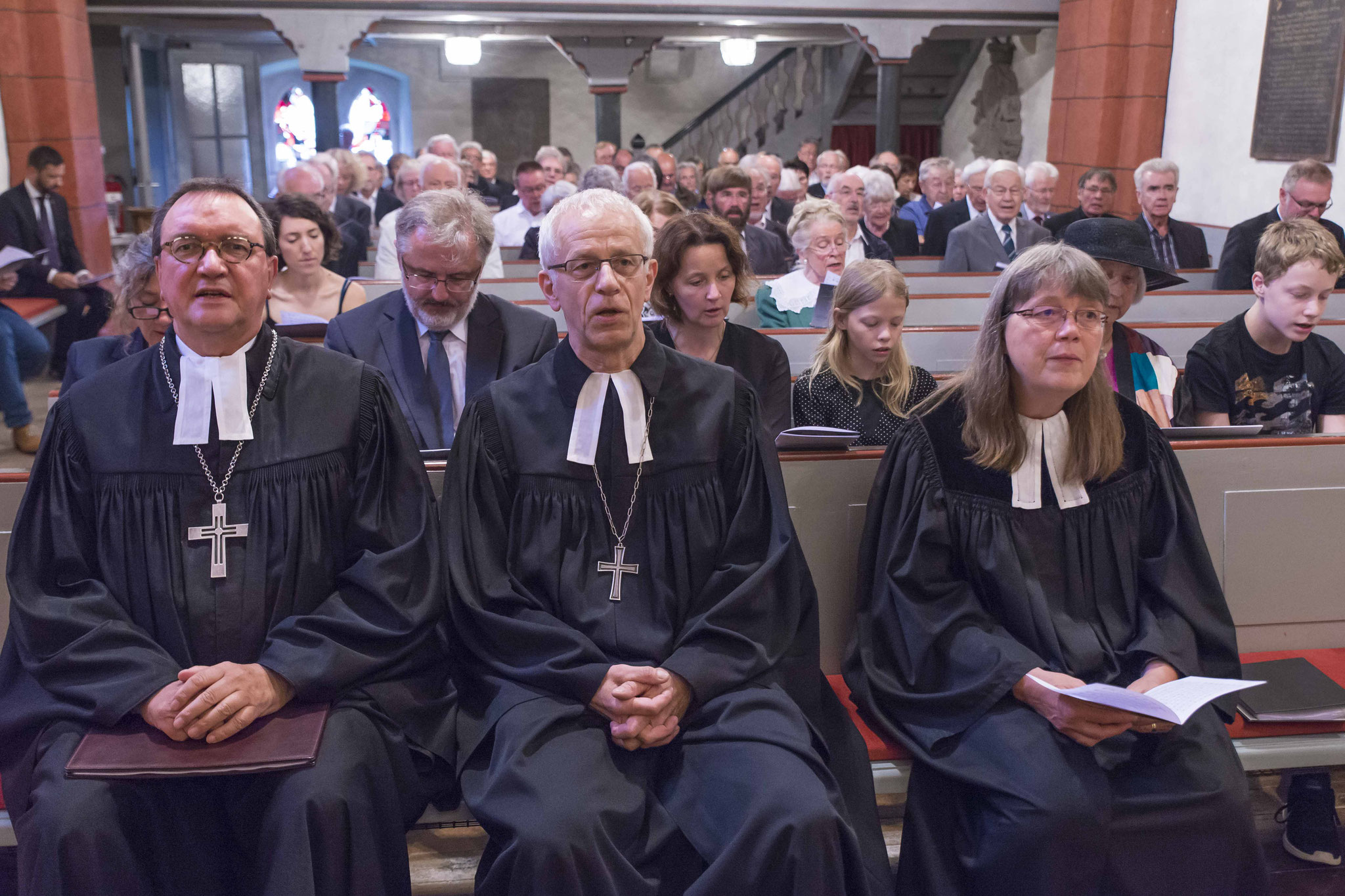 Bischof Prof. Dr. Martin Hein, Propst Helmut Wöllenstein, Pfarrerin Barbara Grenz. Dahinter Angehörige und Gottesdienstbesucher