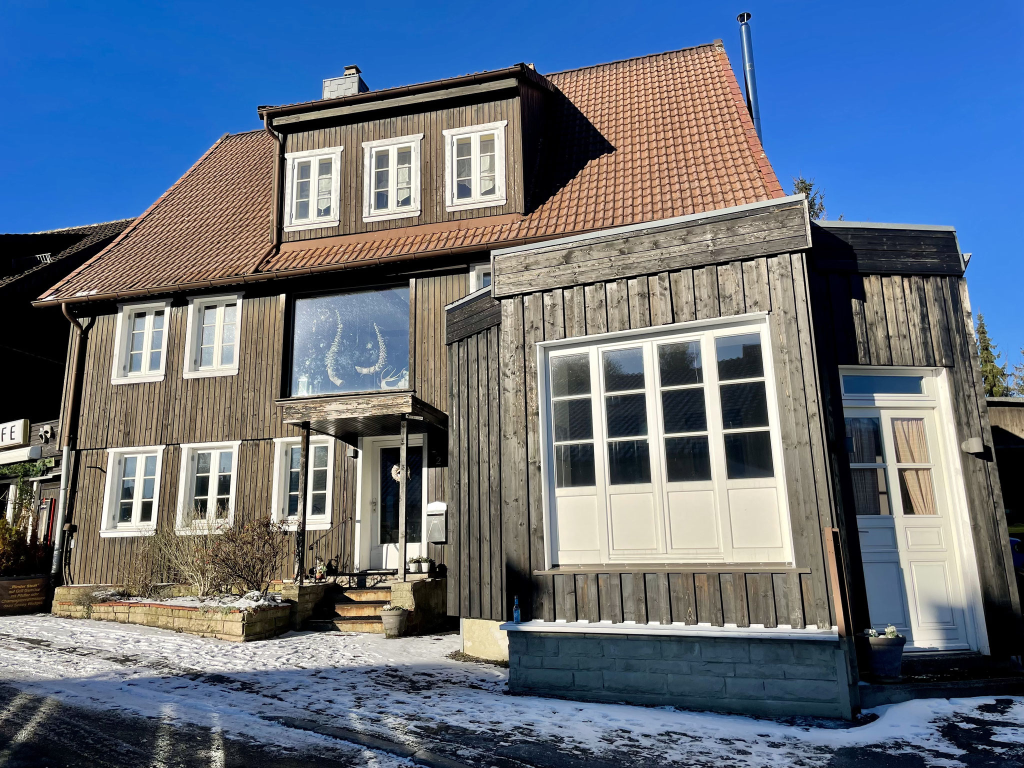 Das Haus ist ein geschichtsträchtiges Fachwerkhaus aus dem Jahr 1879. Der Eingang befindet sich im Bild mittig-links.