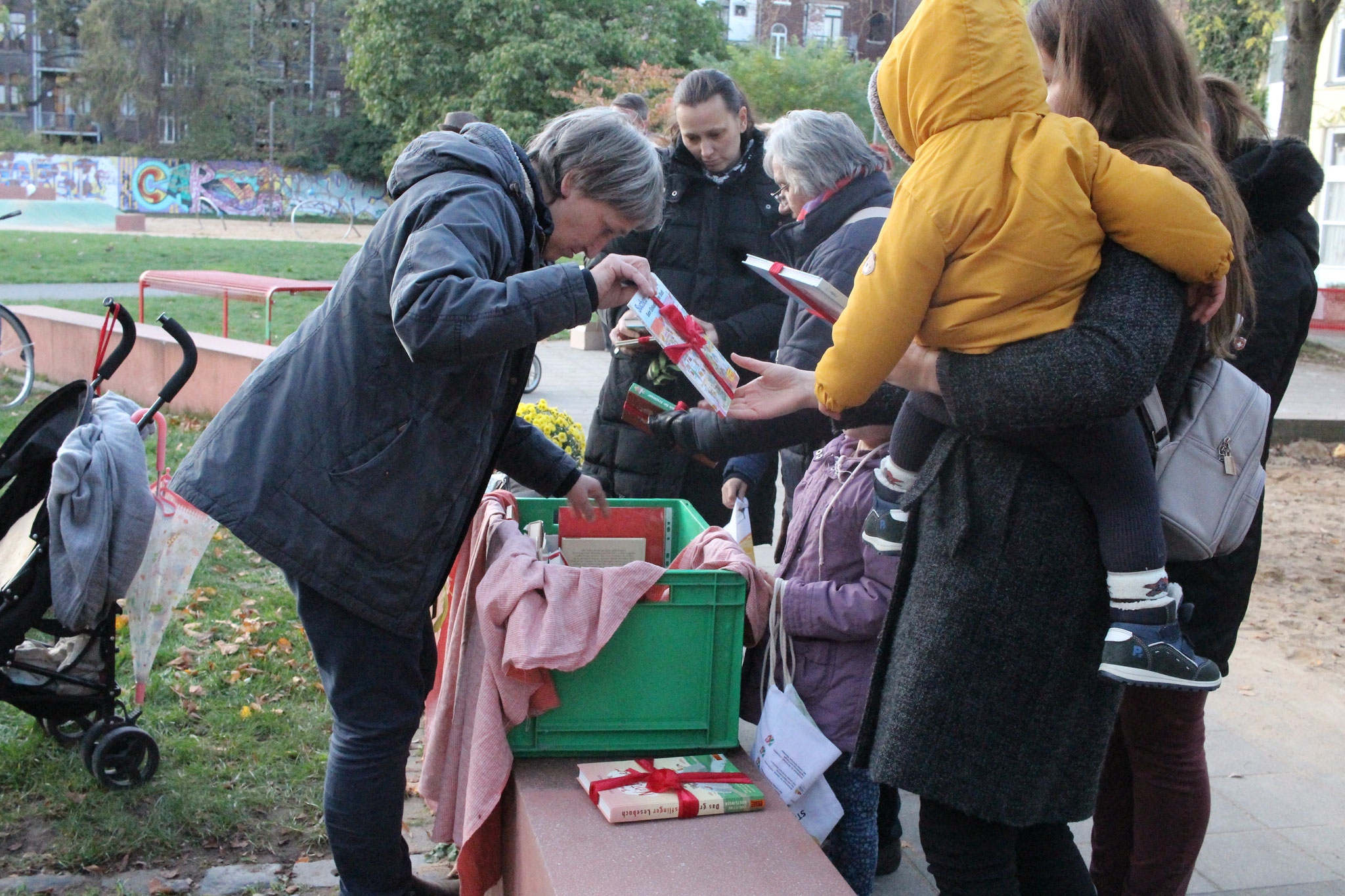 Gabi Schönau von der nachbarschaft köln-mülheim-nord e. V. gibt die schön verpackten Bücher an die Kinder aus.