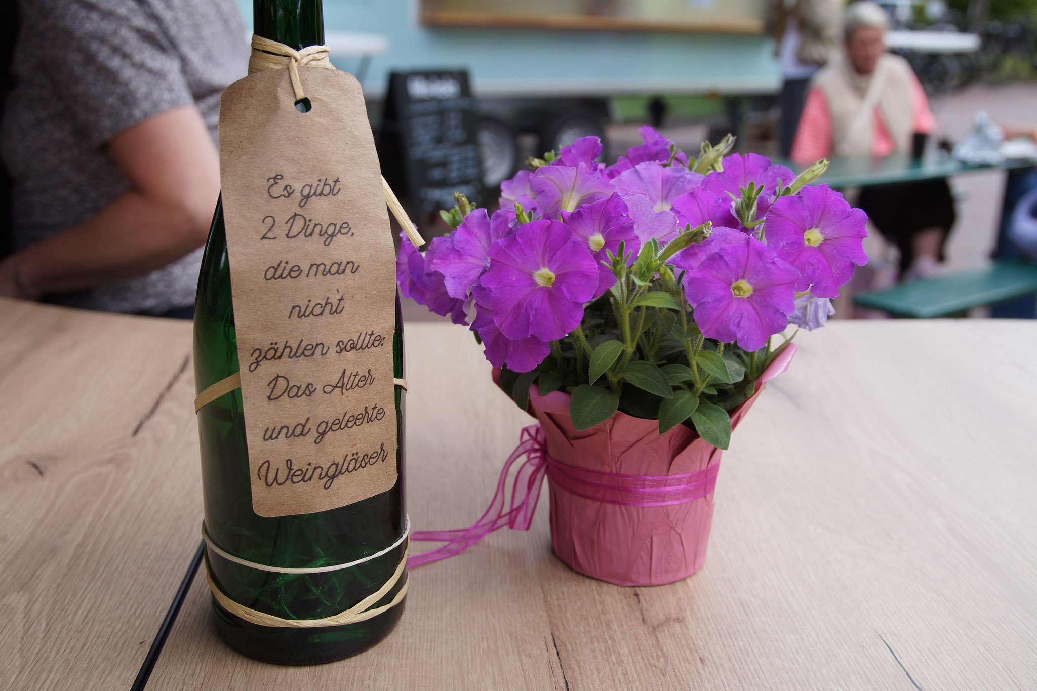 Eine Blume und eine Flasche Wein auf einem Tisch