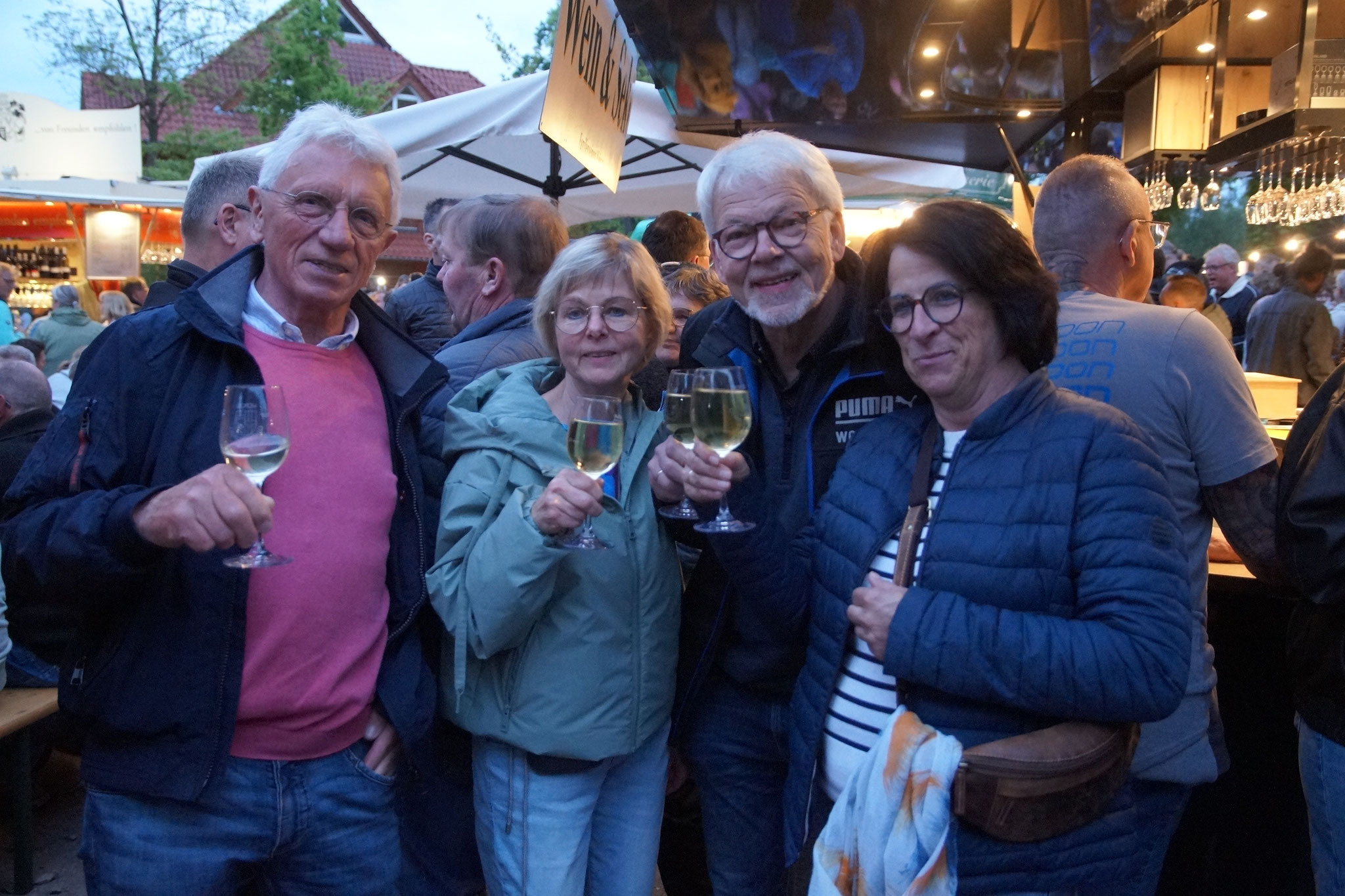 4 erwachsene Menschen mit Weinglas in der Hand