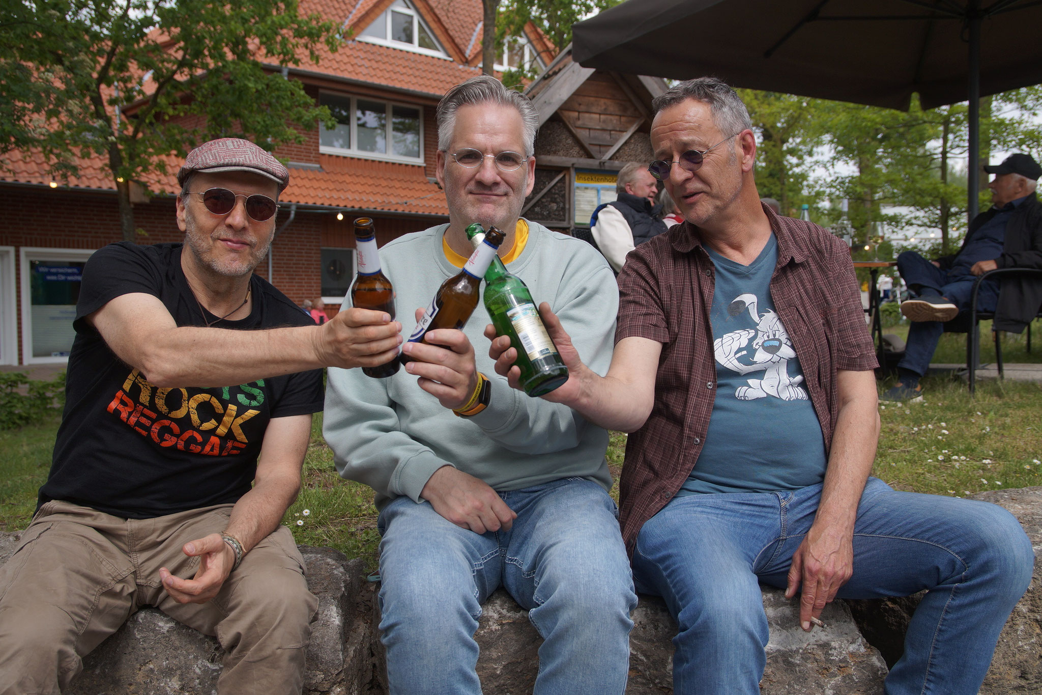 Drei Männer prosten sich mit Bierflaschen zu