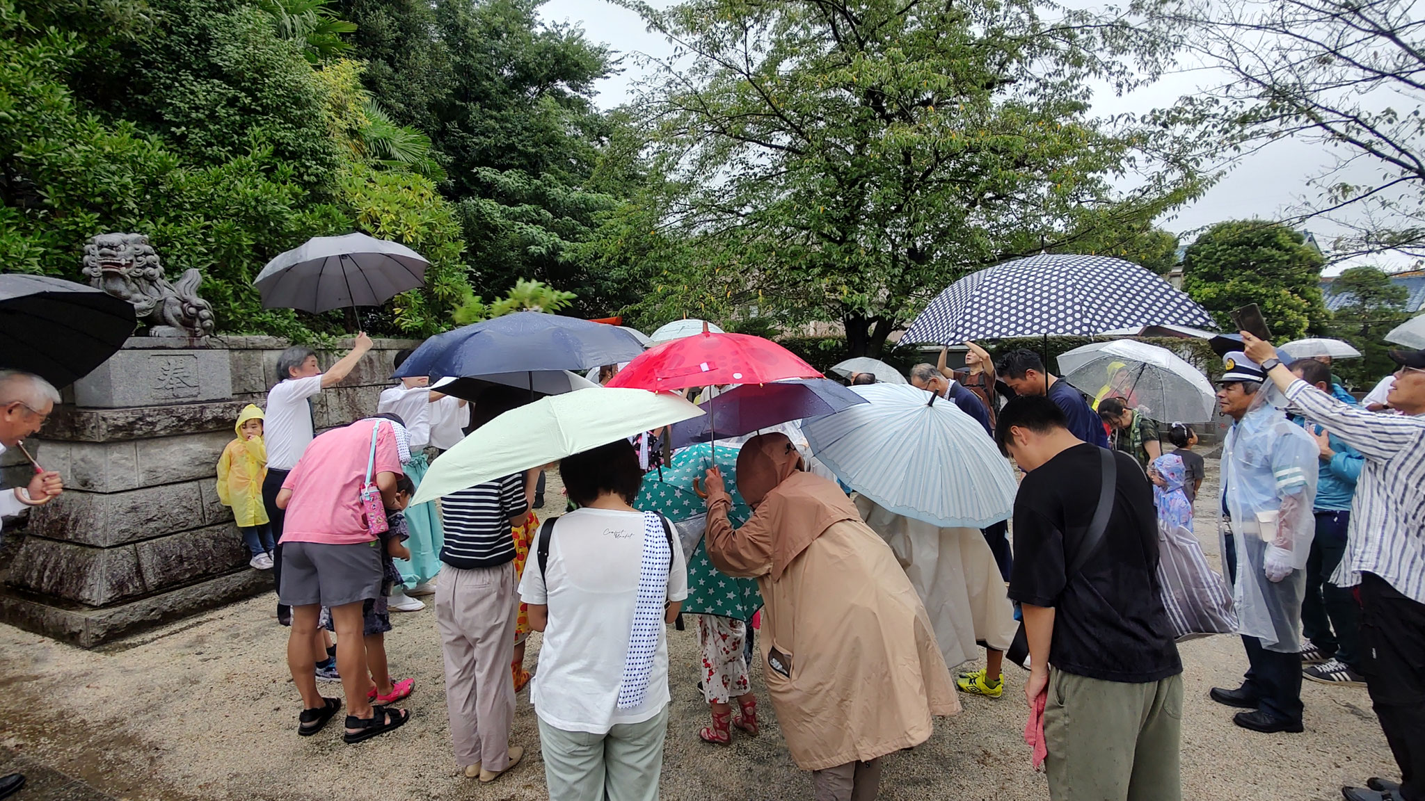 雨は時々、強くなる中で参加者も頭を下げます