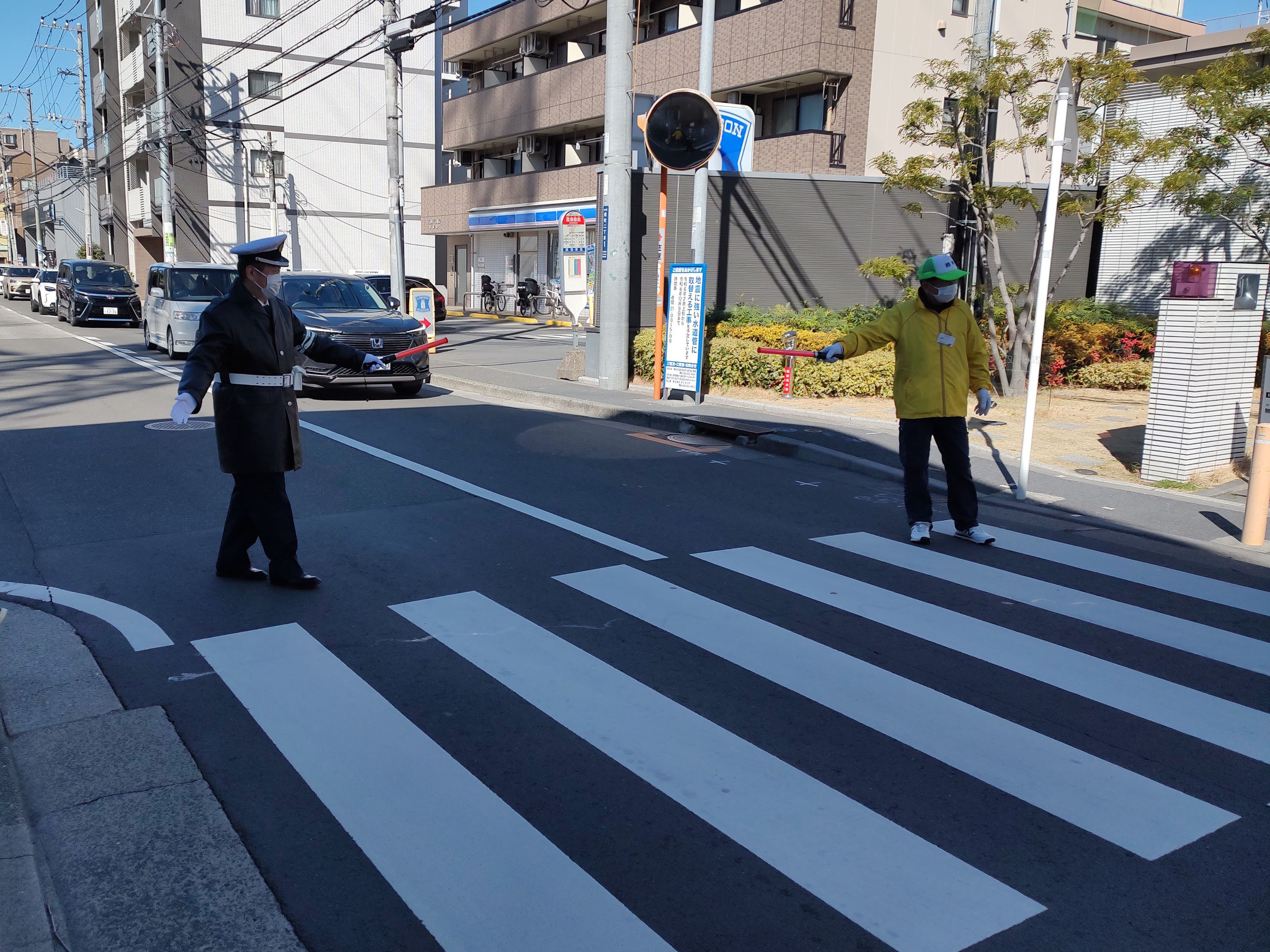 安全協会と町内会役員が歩行者を誘導。