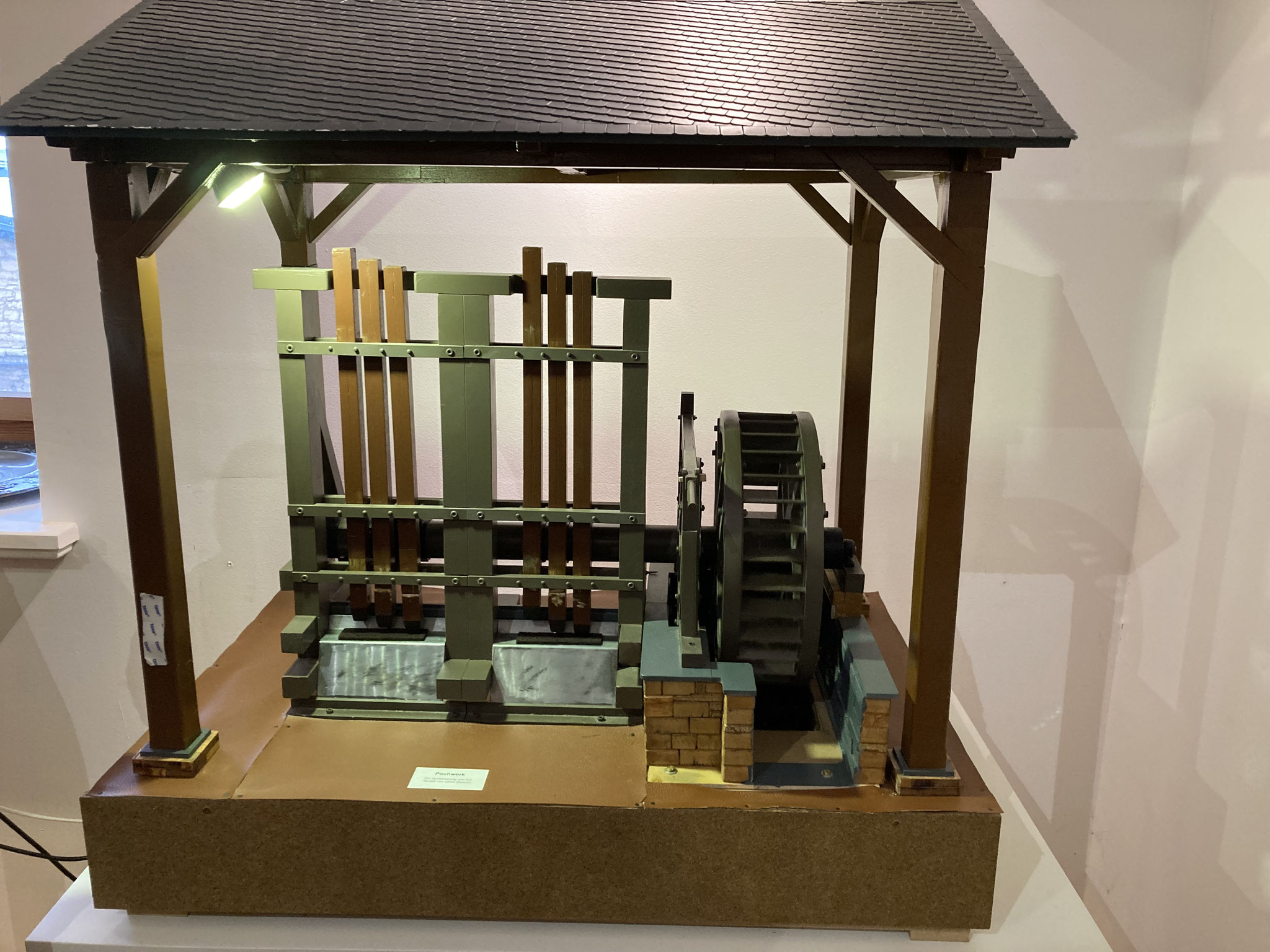 Model of a crusher with six wooden stamps crushing rock and slag, driven by a water wheel.