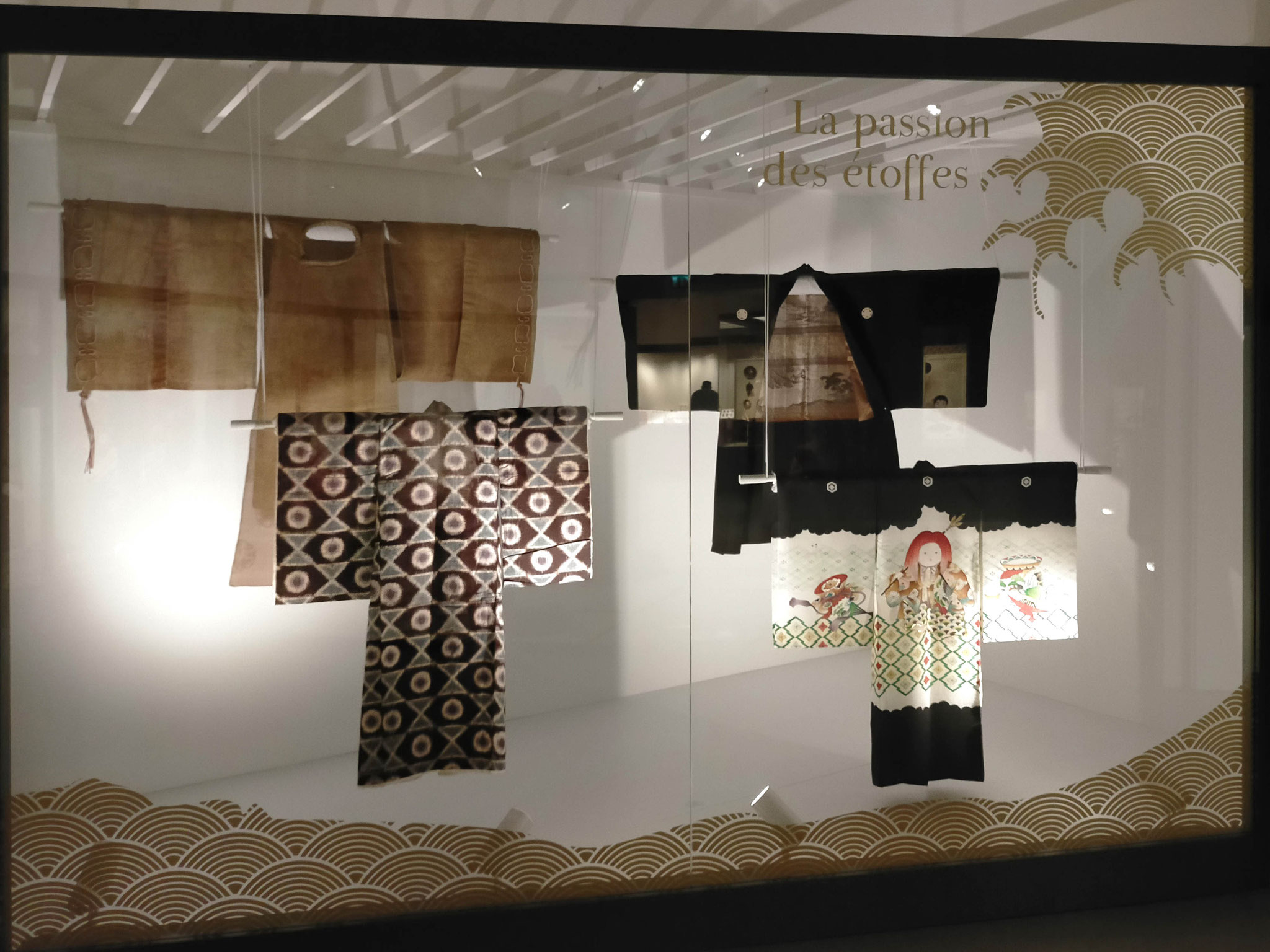 Vitrine des kimonos d'hommes et d'enfants (MARQ). Adhésif doré, découpe numérique. Exposition "Japon. Archipel des arts", musée Crozatier