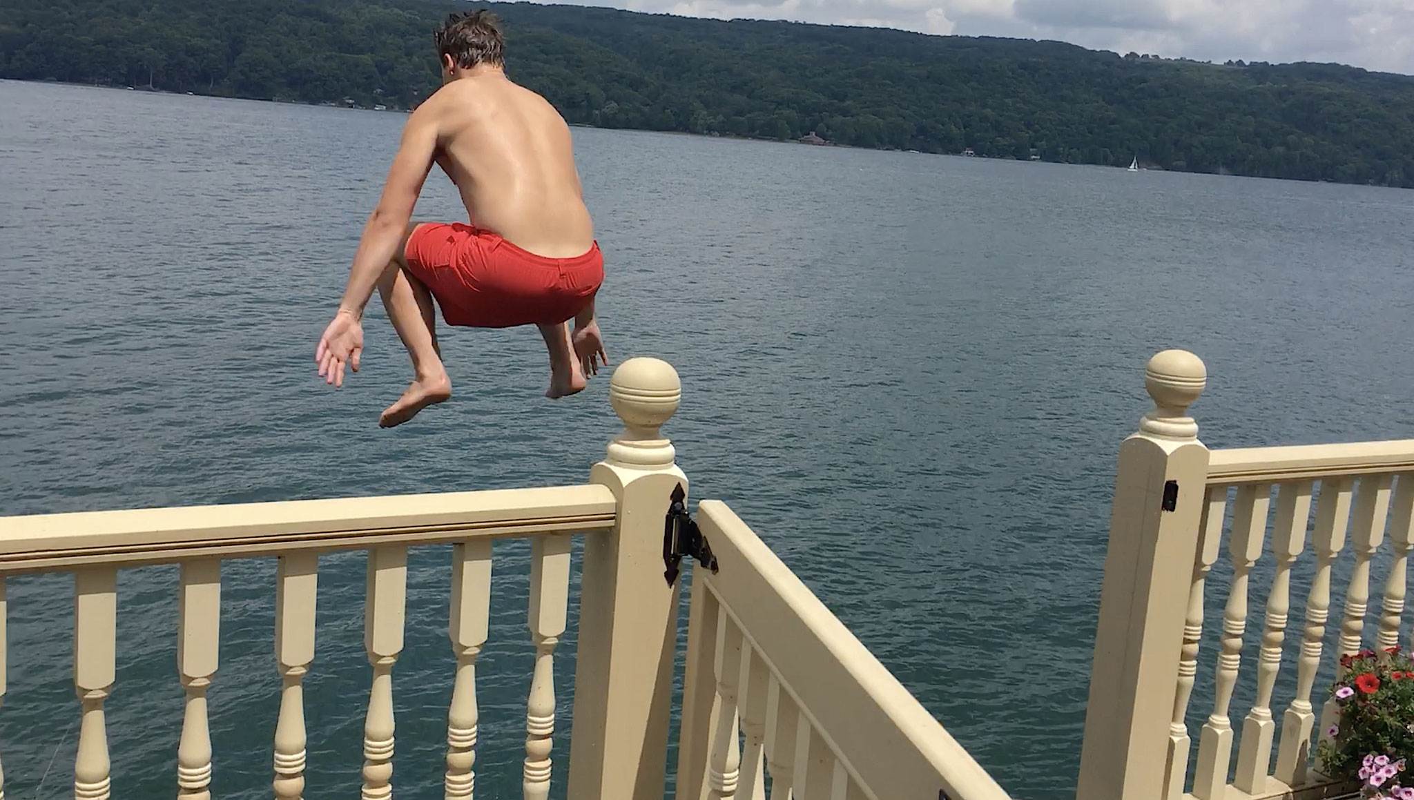 Jack jumping off the trampoline into the water from the boathouse, 7-2020