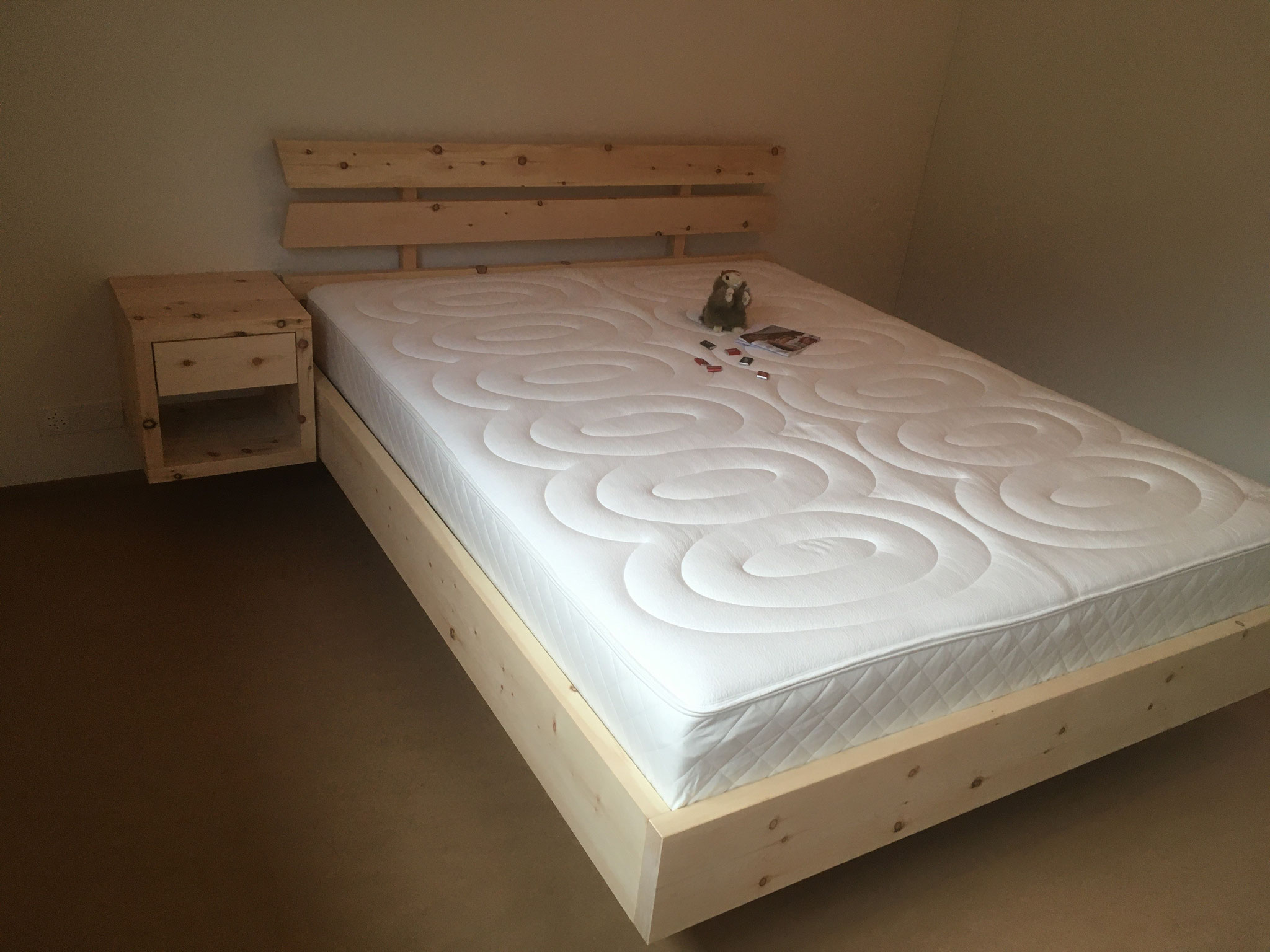 Arven Bett mit passendem Nachttischli und dem kompakten Designa Bettinhalt von Hüsler Nest