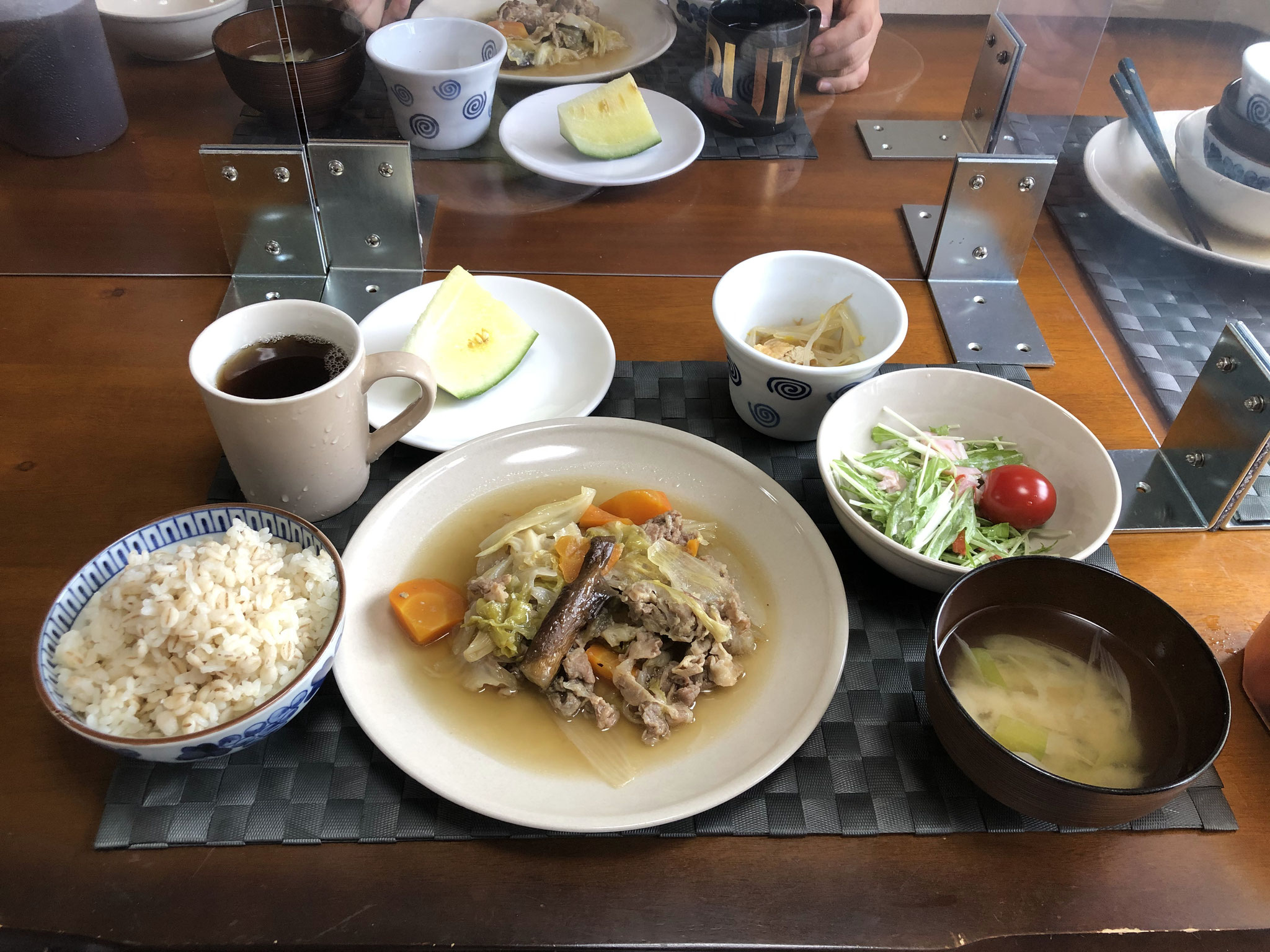 7月11日土曜日、Ohana朝食「野菜炒め（キャベツ、人参、玉ねぎ、ナス、豚肉）、サラダ（水菜、ハム、カニカマ、プチトマト）、みそ汁（ねぎ）、もやしのナムル、スイカ」