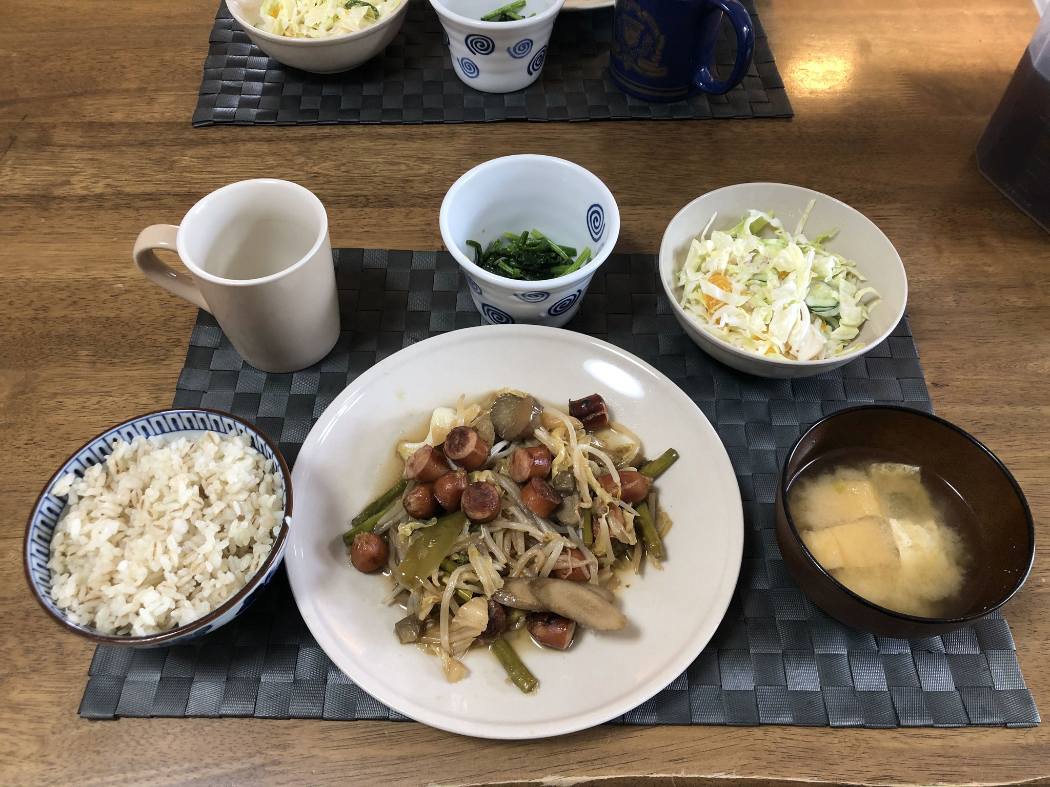 5月9日土曜日、Ohana朝食「ごぼうとウインナーの野菜炒め（ネギ、キャベツ、ナス、もやし、アスパラ）、ほうれん草の胡麻和え、サラダ（キャベツ、みかん、ハム、きゅうり）、みそ汁（油揚げ、ねぎ）」