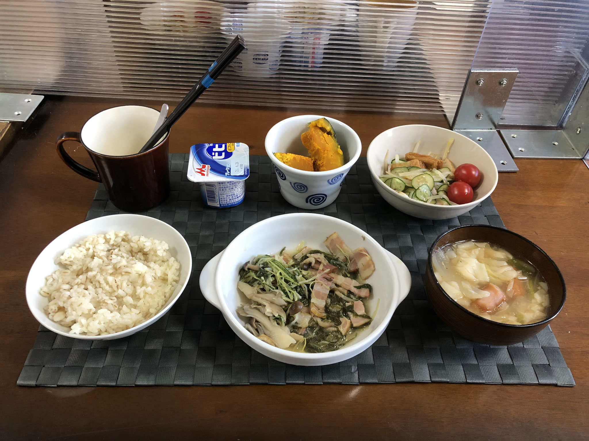 4月12日月曜日、Ohana朝食「水菜とベーコンの炒め物（しめじ、舞茸）、もやしとハムのサッパリサラダ（きゅうり、プチトマト、さつま揚げ）、ワンタンスープ（玉ねぎ、ねぎ、ウインナー）、かぼちゃの煮物、ヨーグルト」