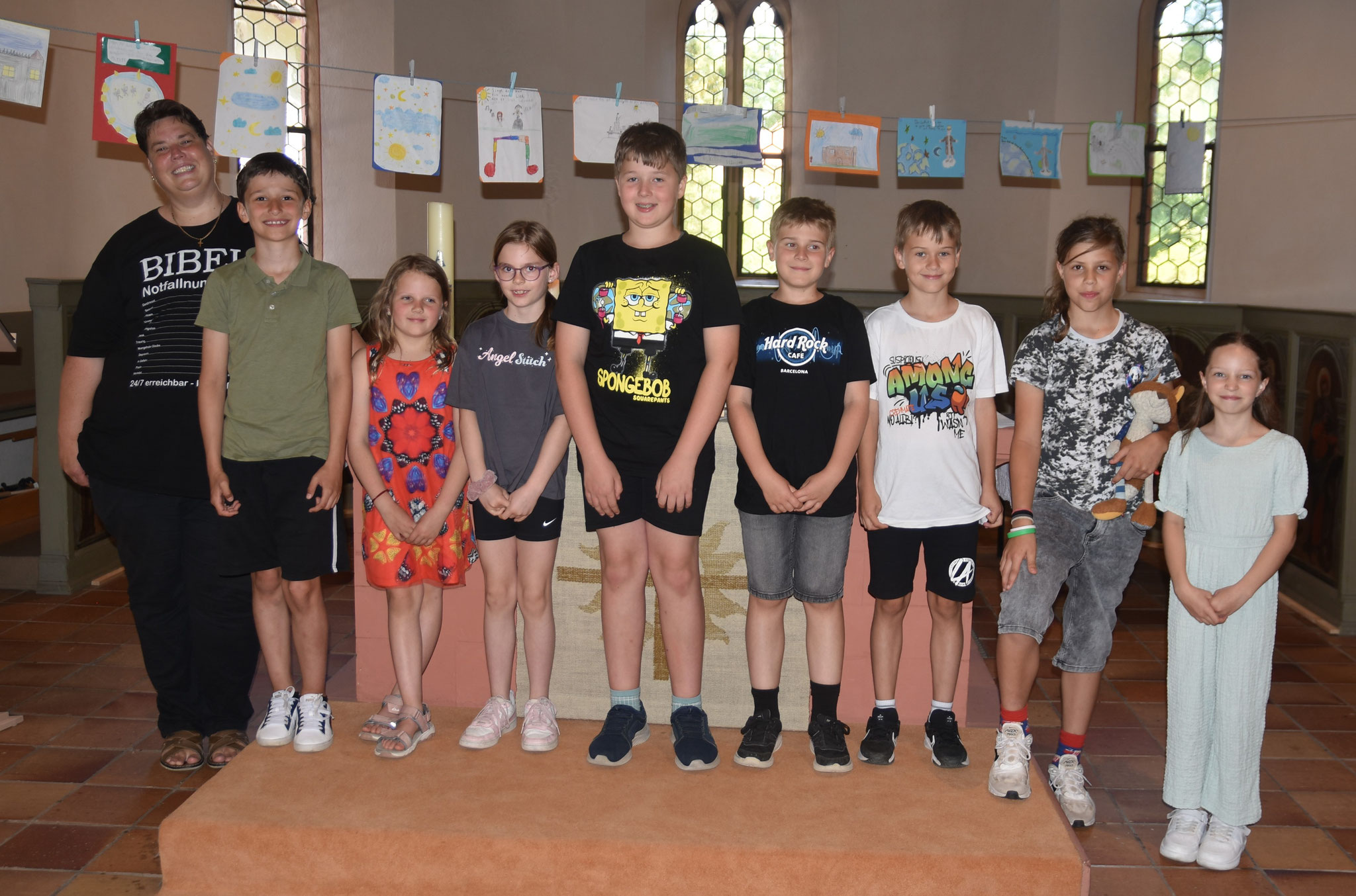 Pfarrerin Tanja Langer mit einem Teil der Lindheimer Dritt- und Viertklässler, die in der Kirche ihre kleinen Kunstwerke ausgestellt haben. Im Religionsunterricht hatten sie sich intensiv mit den Psalmen befasst. Danach haben sie künstlerisch umgesetzt, w