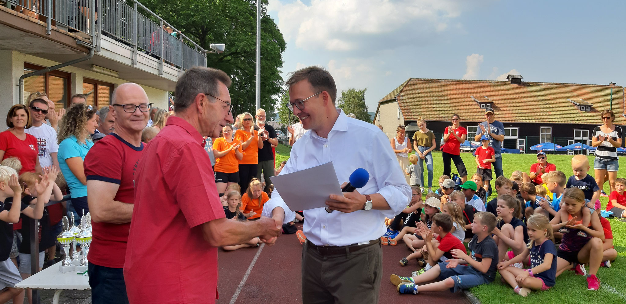 Erster Kreisbeigeordneter Frederik Schmitt übergibt den Förderbescheid für das Fest.