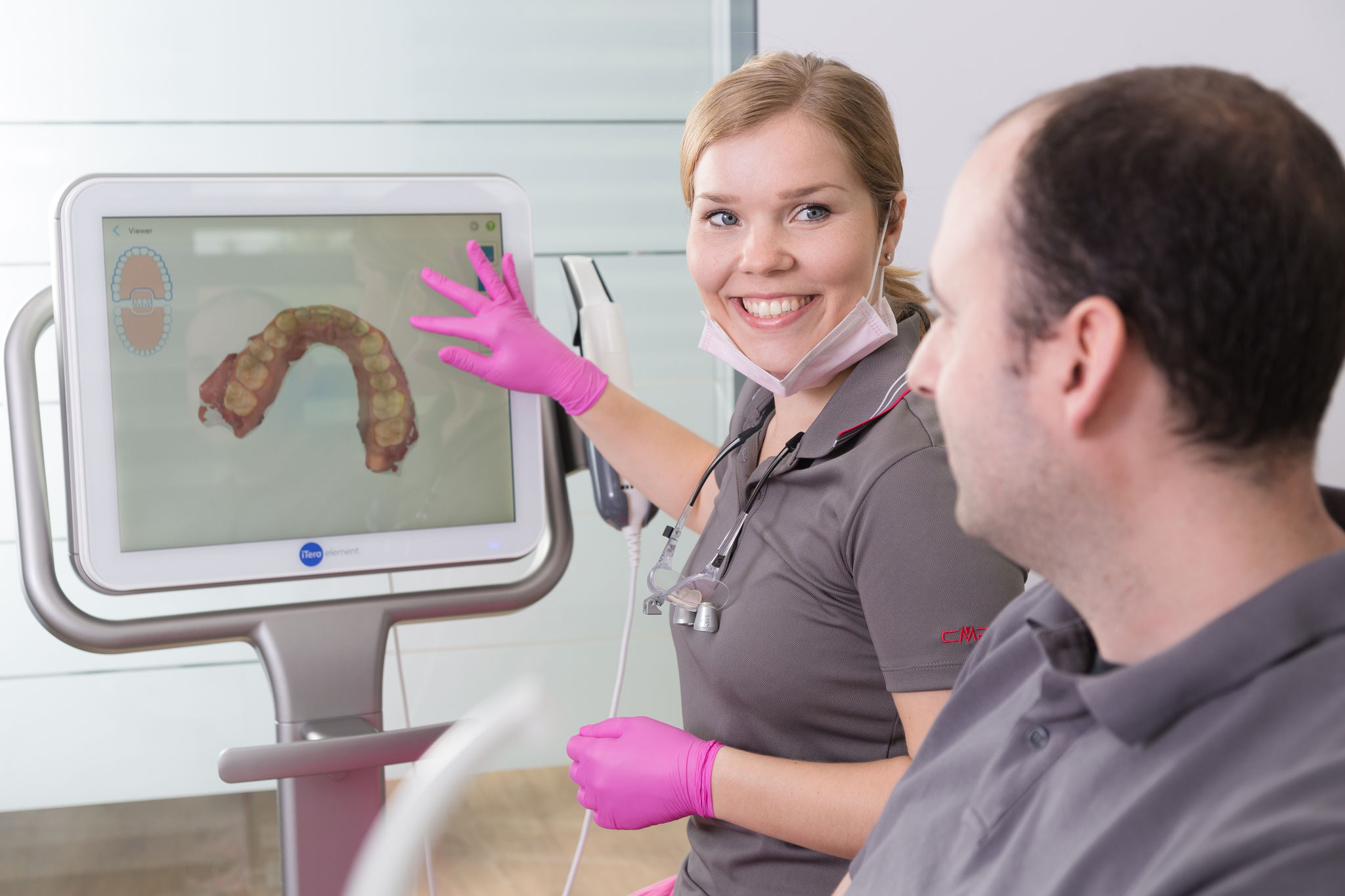 Zahnärztin erklärt Behandlung am Monitor – authentisches Praxisfoto