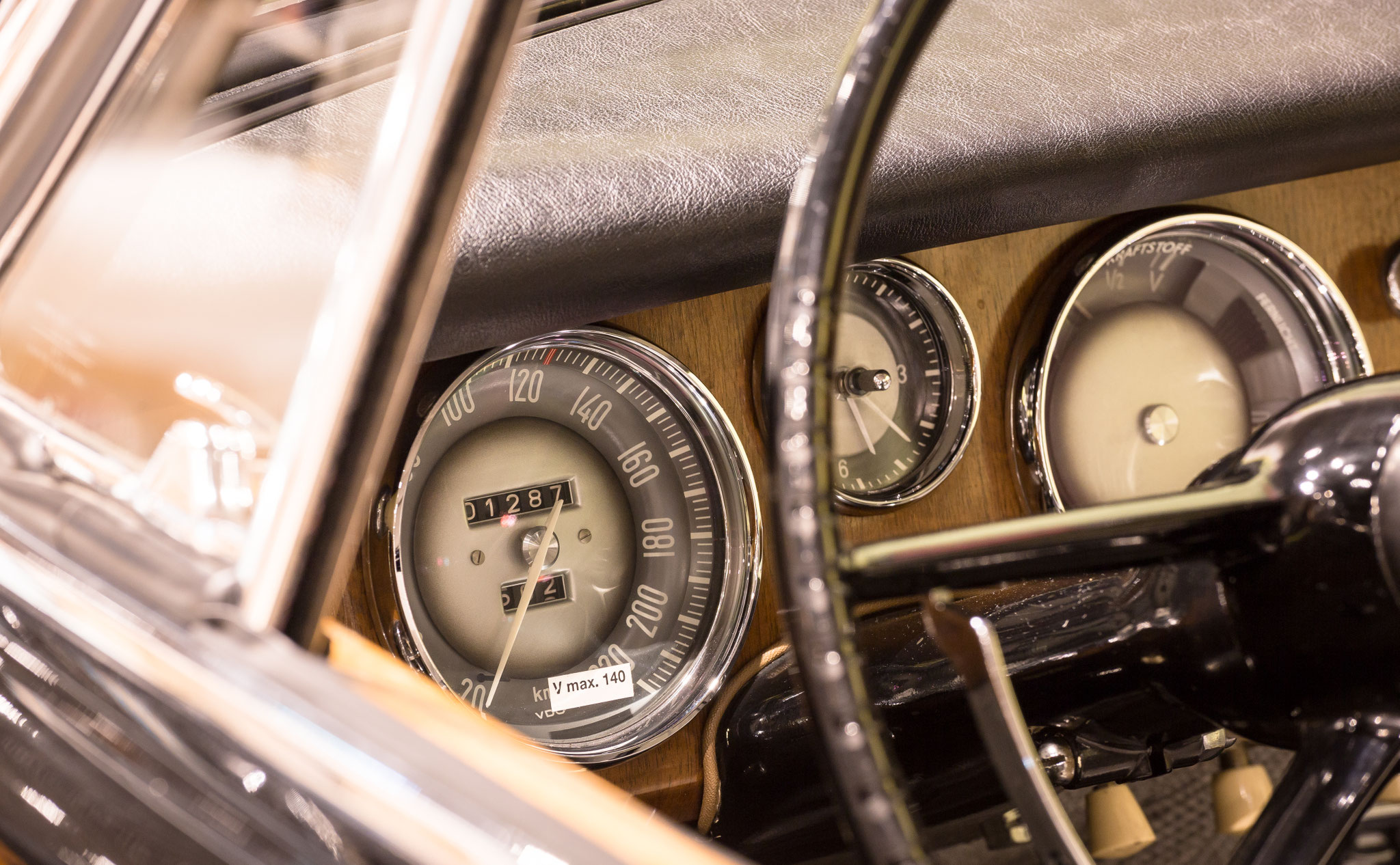 Detailaufnahme eines Oldtimer-Cockpits mit Lenkrad und Tachometer – stimmungsvolles Werbefoto
