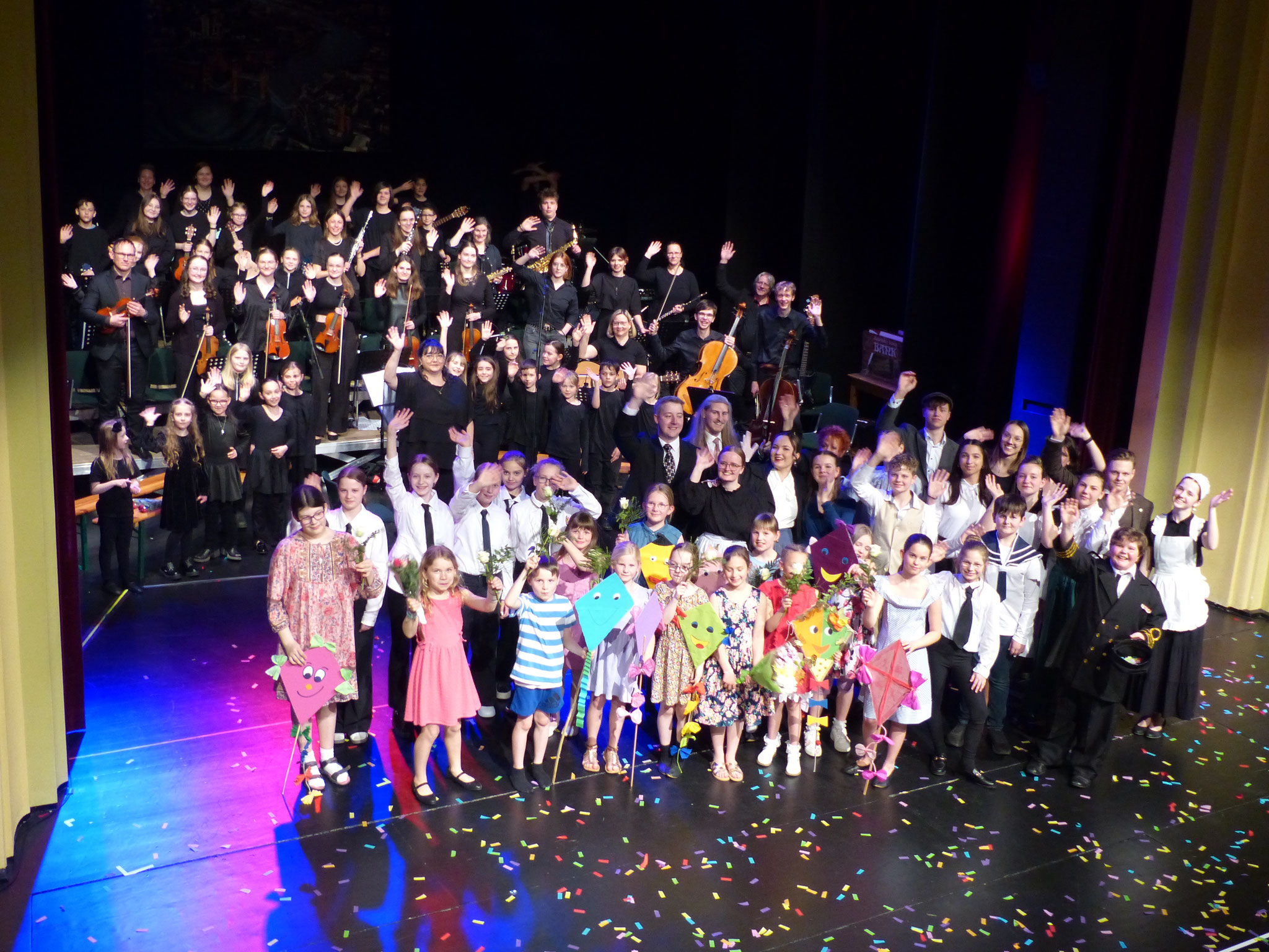 Die Gitarrenschüler von Sintje Klingner, das Orchester um Marie-Lys Langlois-Behrenz, der Chor der Grundschule Pestalozzi und die Schauspieler aus den Musiktheaterklassen von Sintje Klingner beim Abschlussbild auf der Bühne.
