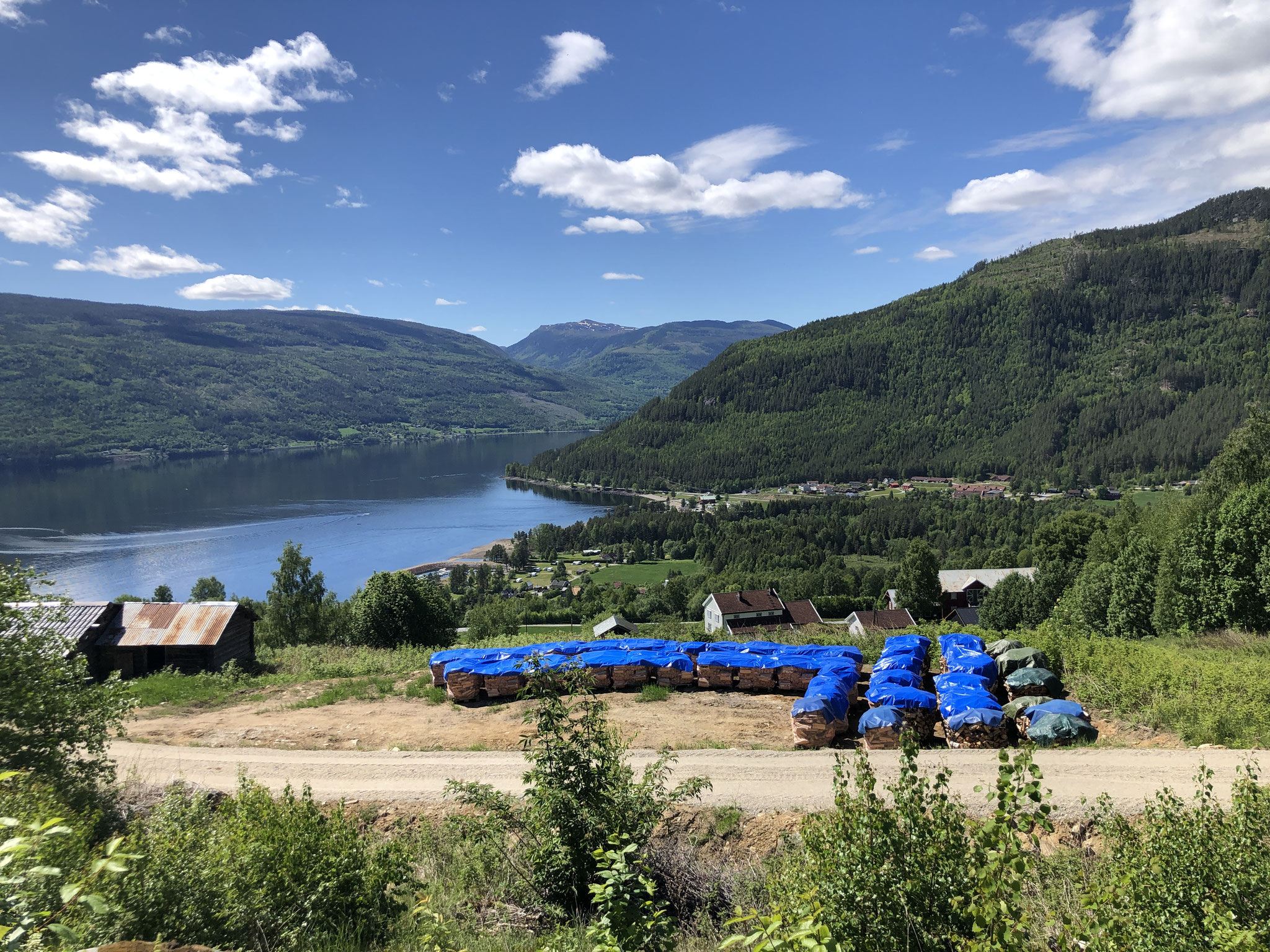 ved vannkanten se du Sjøtveit båtshavn og helt bakerst med den rø loven Sandviken Camping