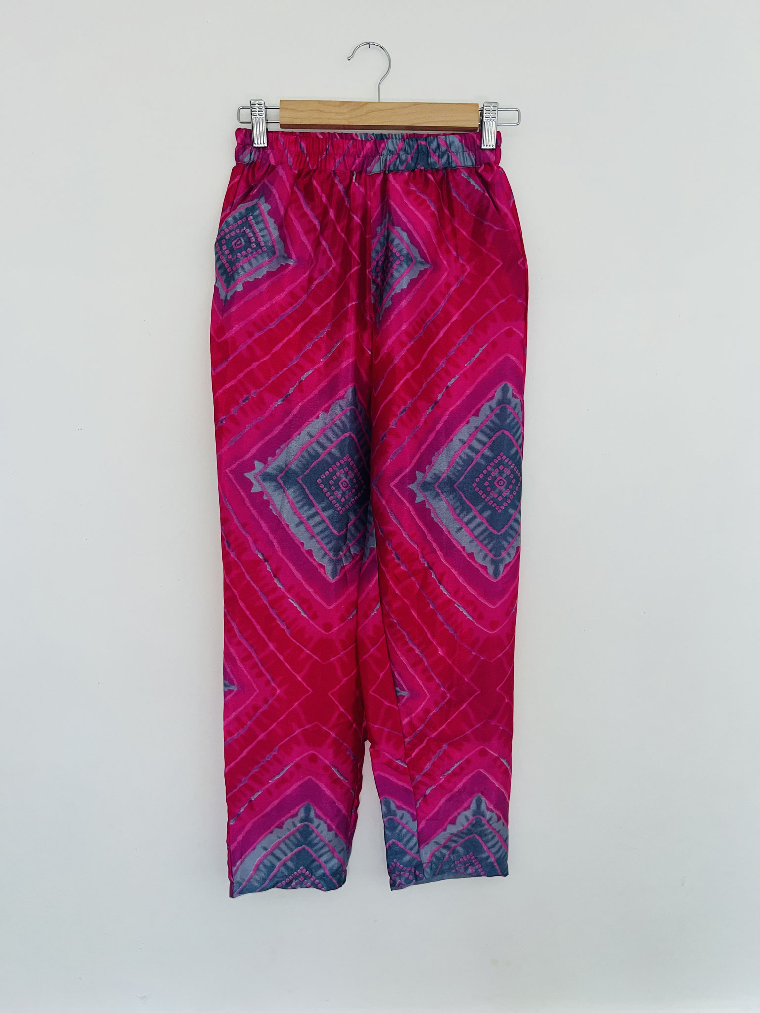 Détail du haut du pantalon – Losanges violets et bleu-gris sur fond rose vif