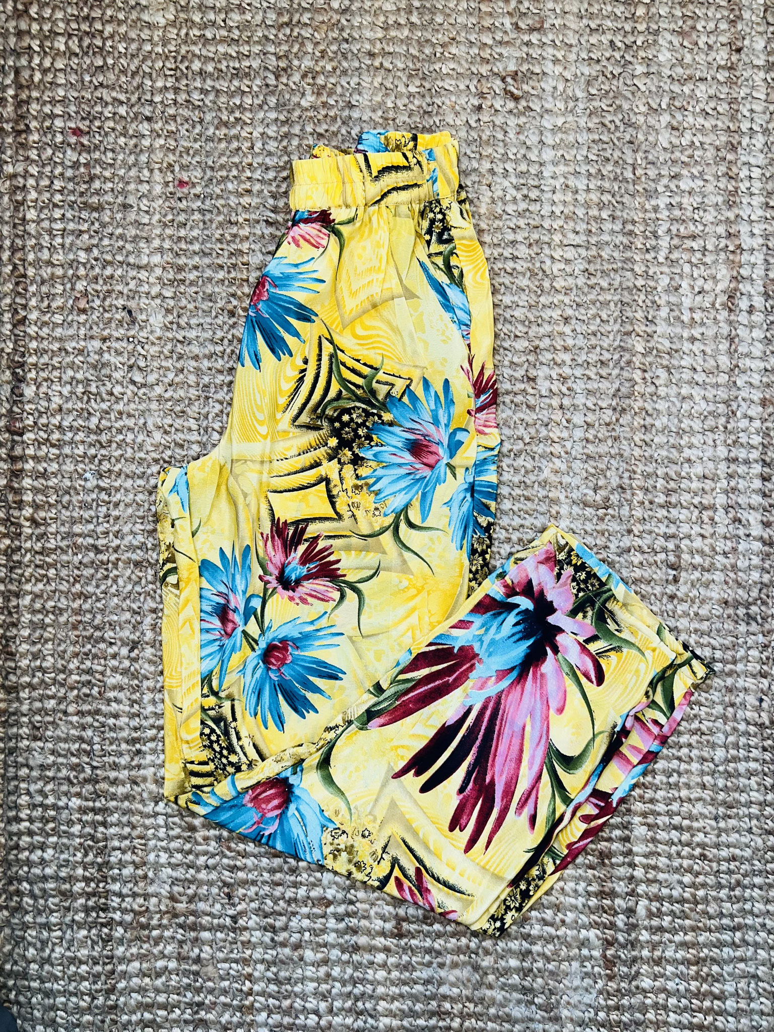 Détail du haut du pantalon – Fleurs fuchsia et bleues sur fond jaune vif