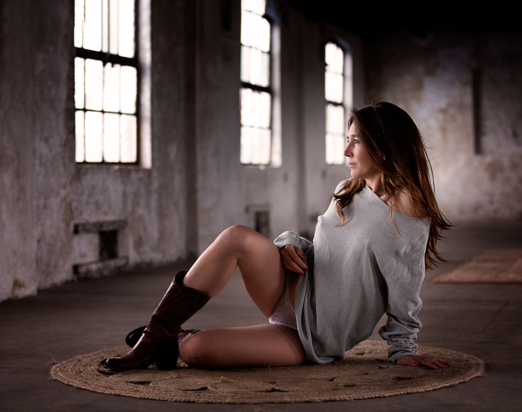 Boudoirportrait with cowboy boots at a robust location in the netherlands