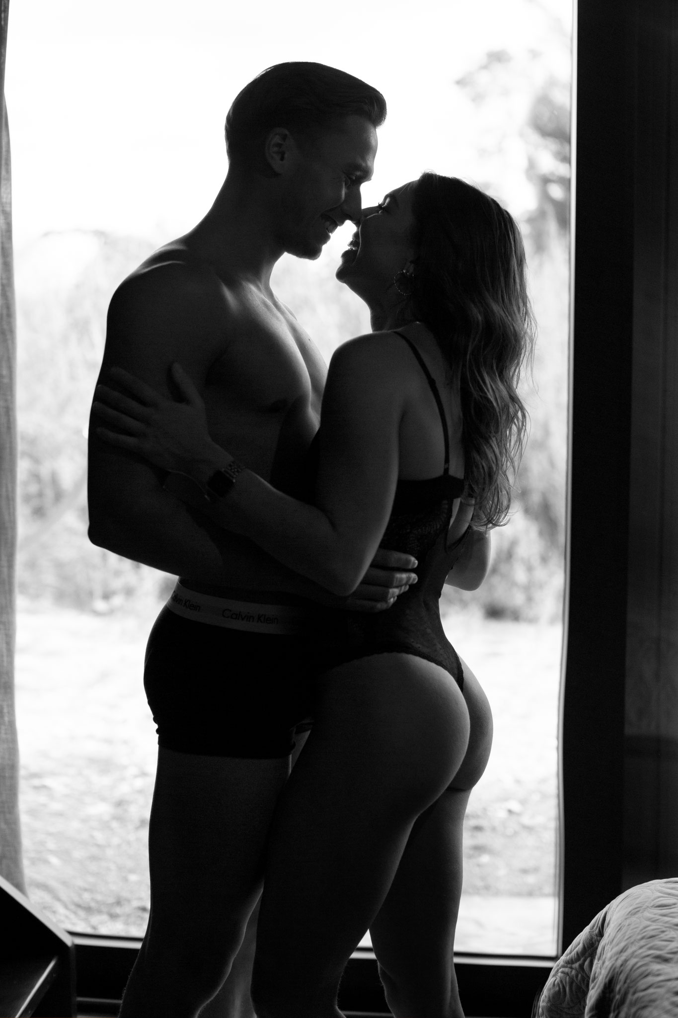 krachtige boudoirfoto van staande man en  vrouw met tegenlicht