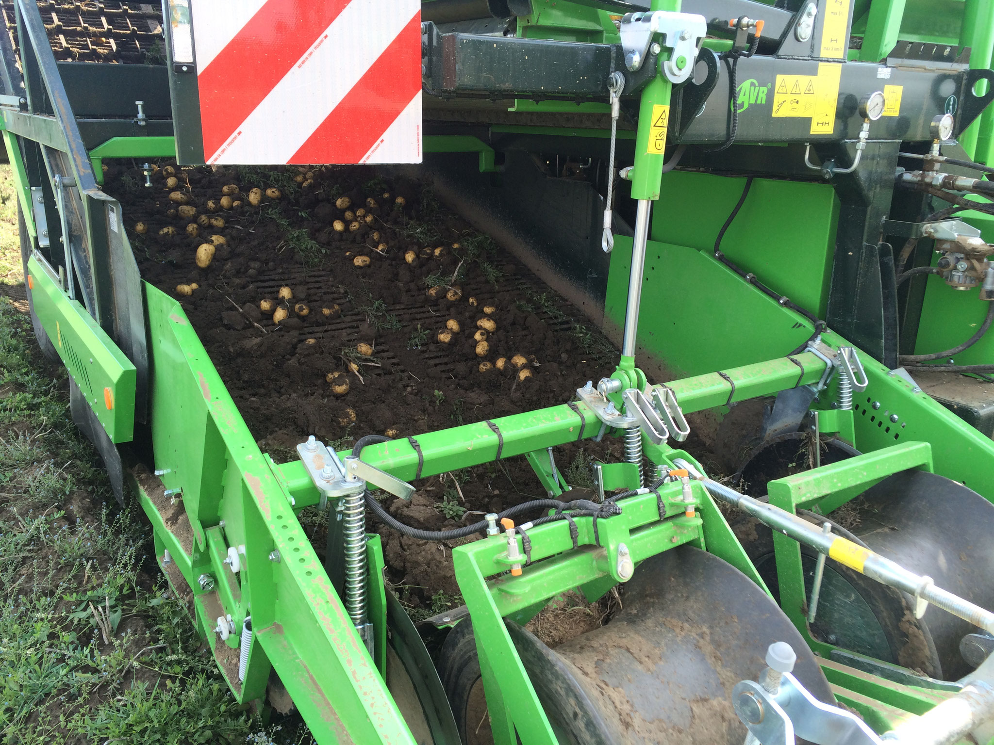 Die Walzen nehmen den Damm auf.  Auf der Siebkette wird die feine Erde abgesiebt.