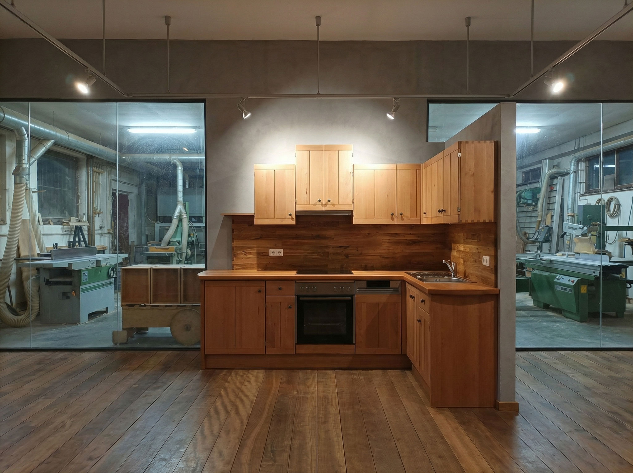 Eine L-förmige Küche in massiver Buche und Eiche im Showroom der Schreinerei Kramhöller mit Blick in die Werkstatt.