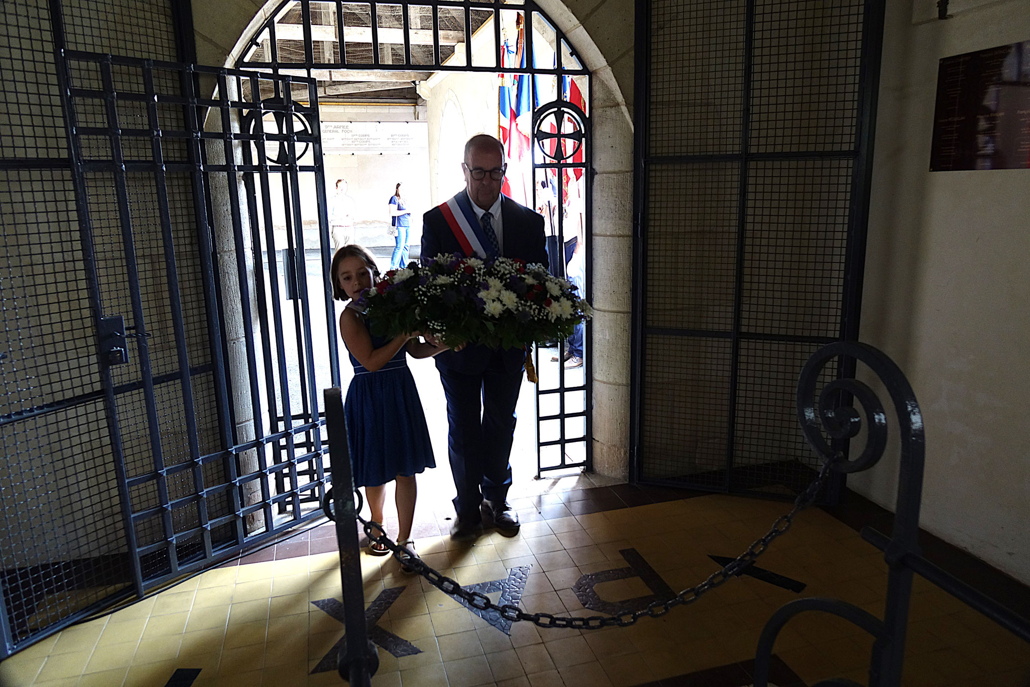 Le maire de Dormans Thierry Barbier dépose l'un des sept coussins de fleurs à l'ossuaire.