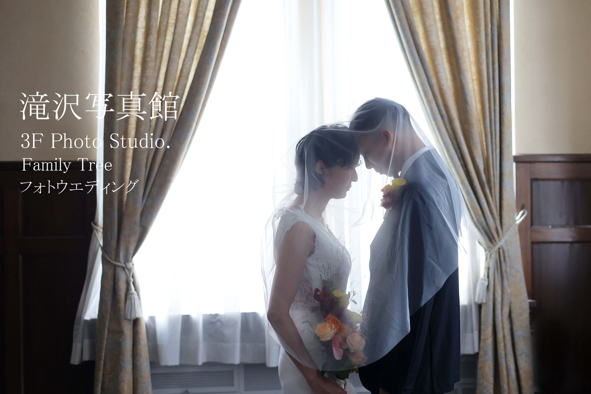 フォトウエディング、新郎新婦向かい合わせでおでこを付けふ二人で一緒にベールの中に入ってのお写真