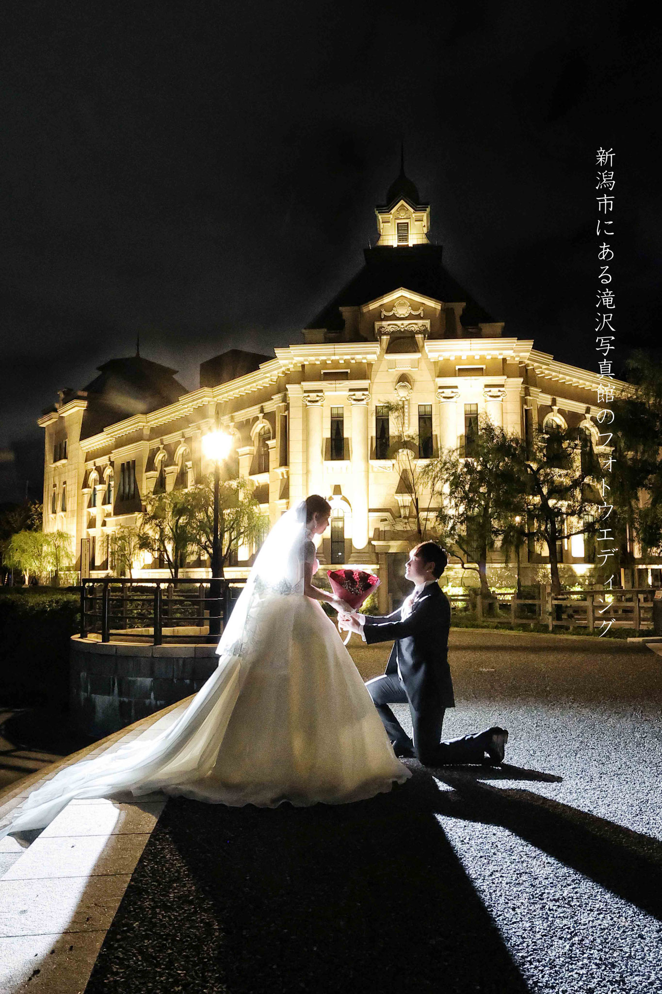 ライトアップされた洋館を背景に夜景の撮影新郎がひざまずき新婦に花束をプレゼントしているドラマチックな結婚式のお写真