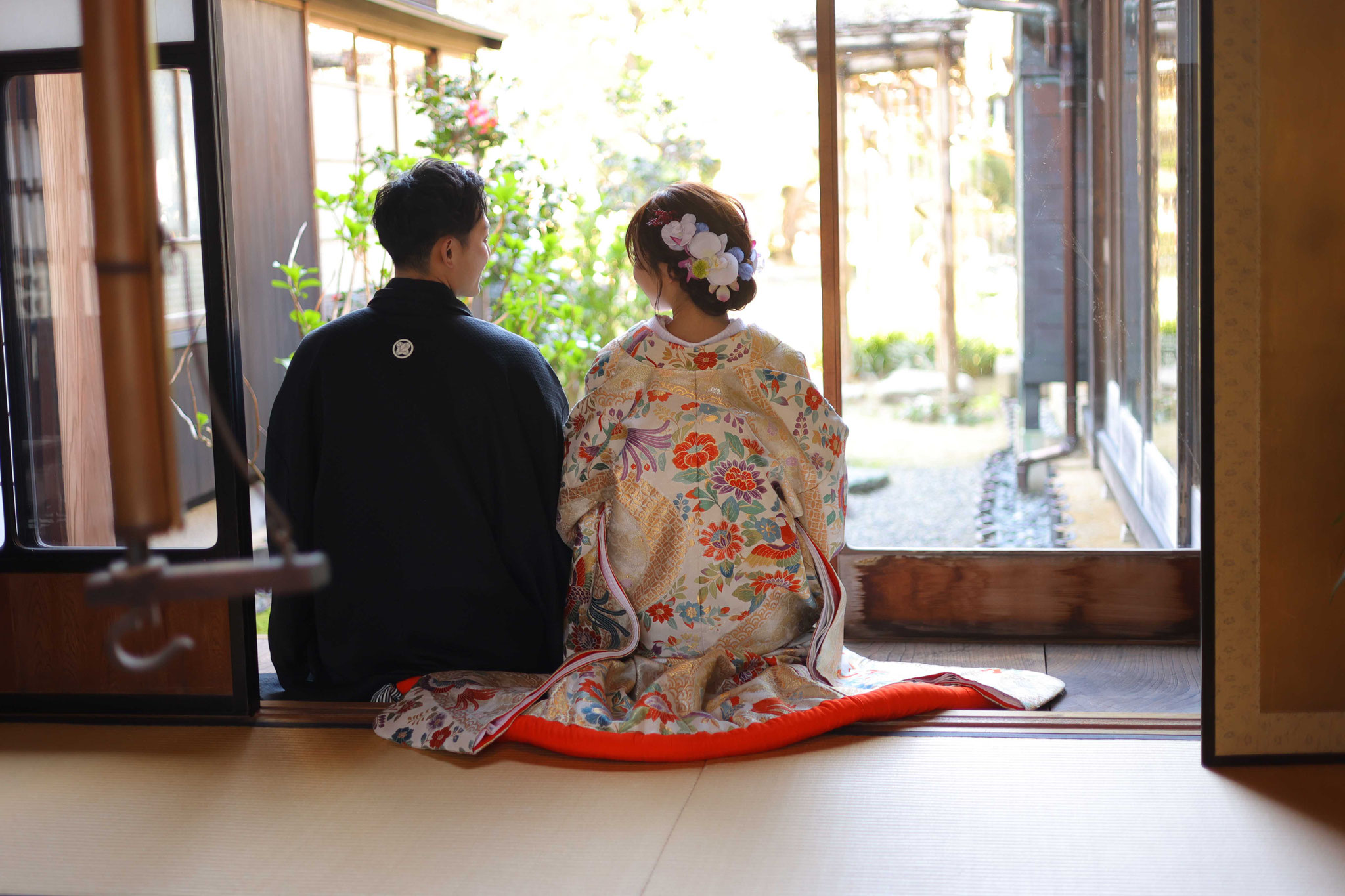 古民家の畳に正座で座っている色打掛、紋服姿の新郎新婦のお写真