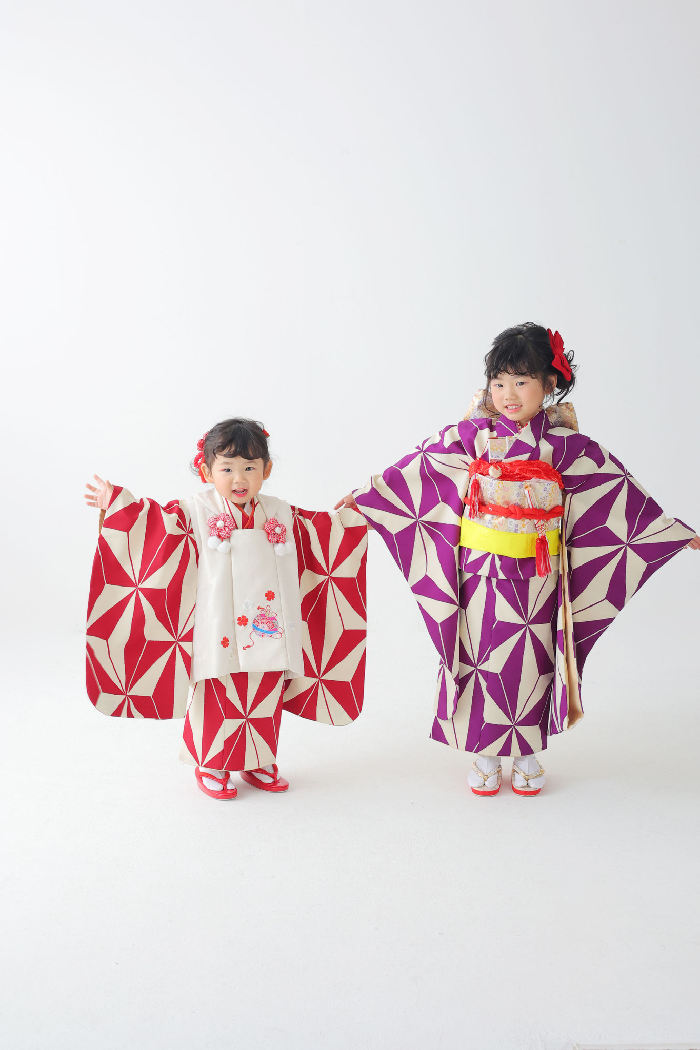 姉妹でお揃いの着物両手を広げて袂を見せるポーズの写真