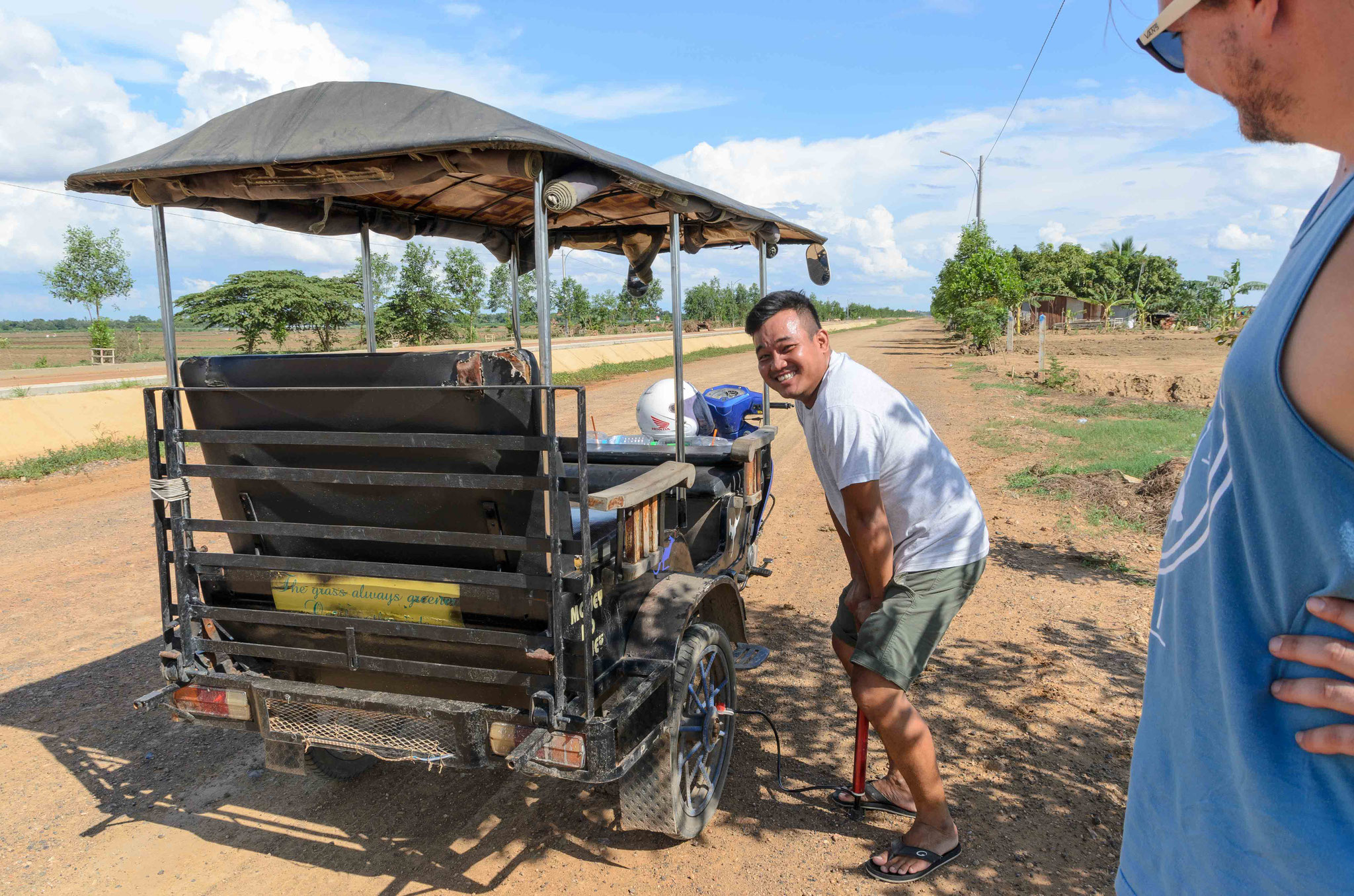 Bun kümmert sich um unseren platten Reifen (später haben wir doch das Tuktuk wechseln müssen)