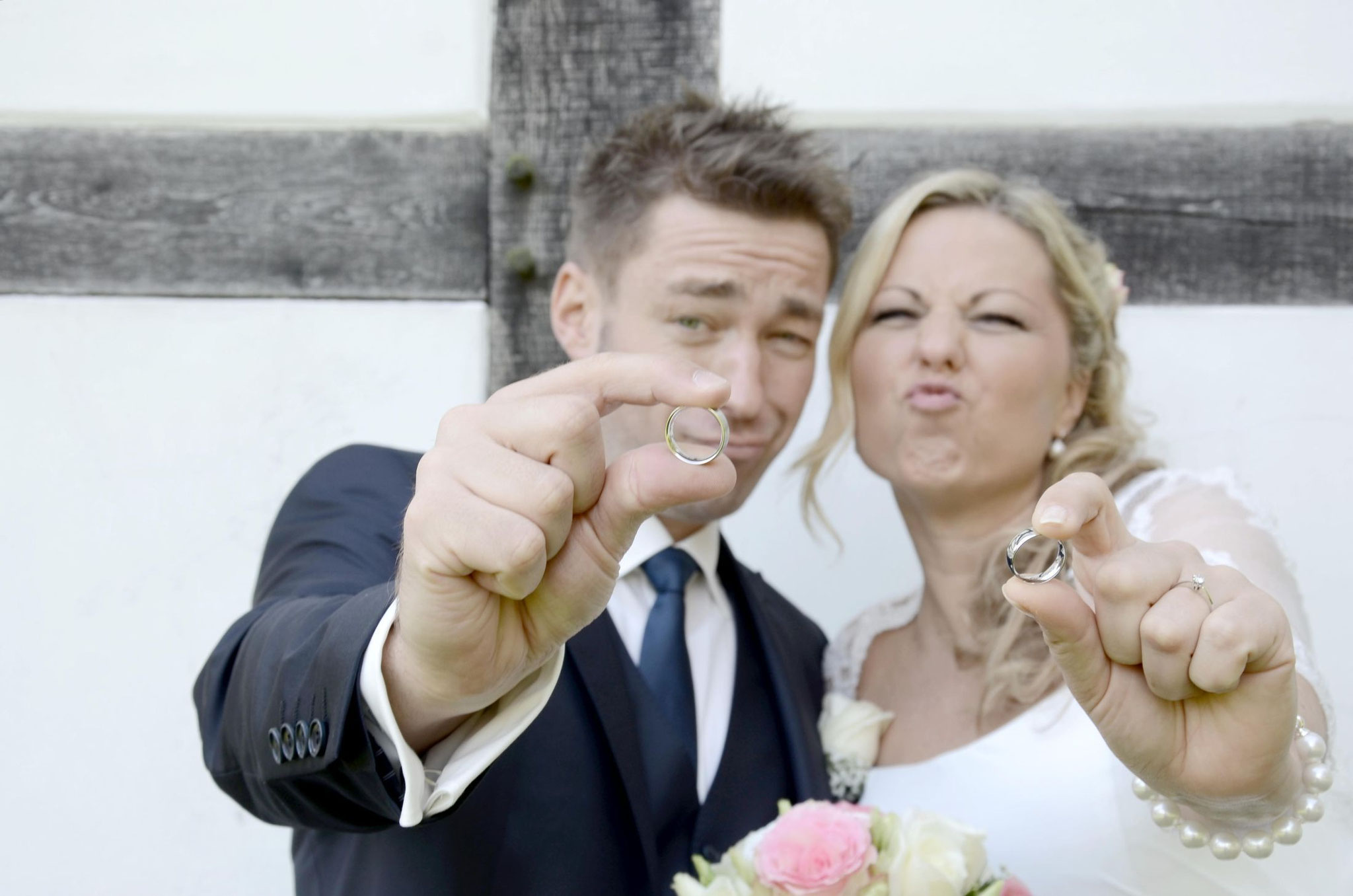 Brautpaar zeigt Ringe in die Kamera – fröhliches Hochzeitsfoto - Fotograf für Hochzeit in Bad Driburg