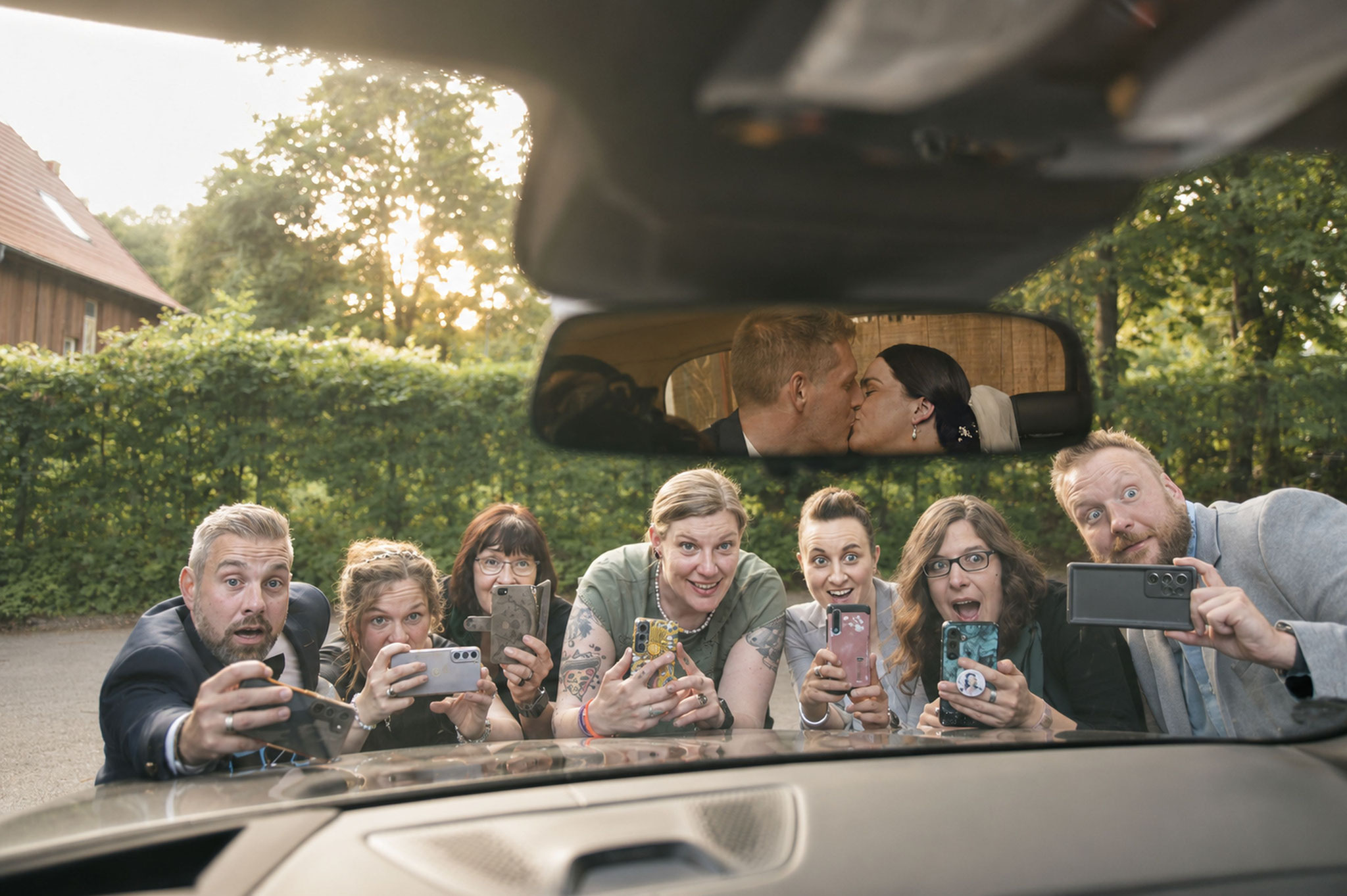 Gäste fotografieren Brautpaar im Auto